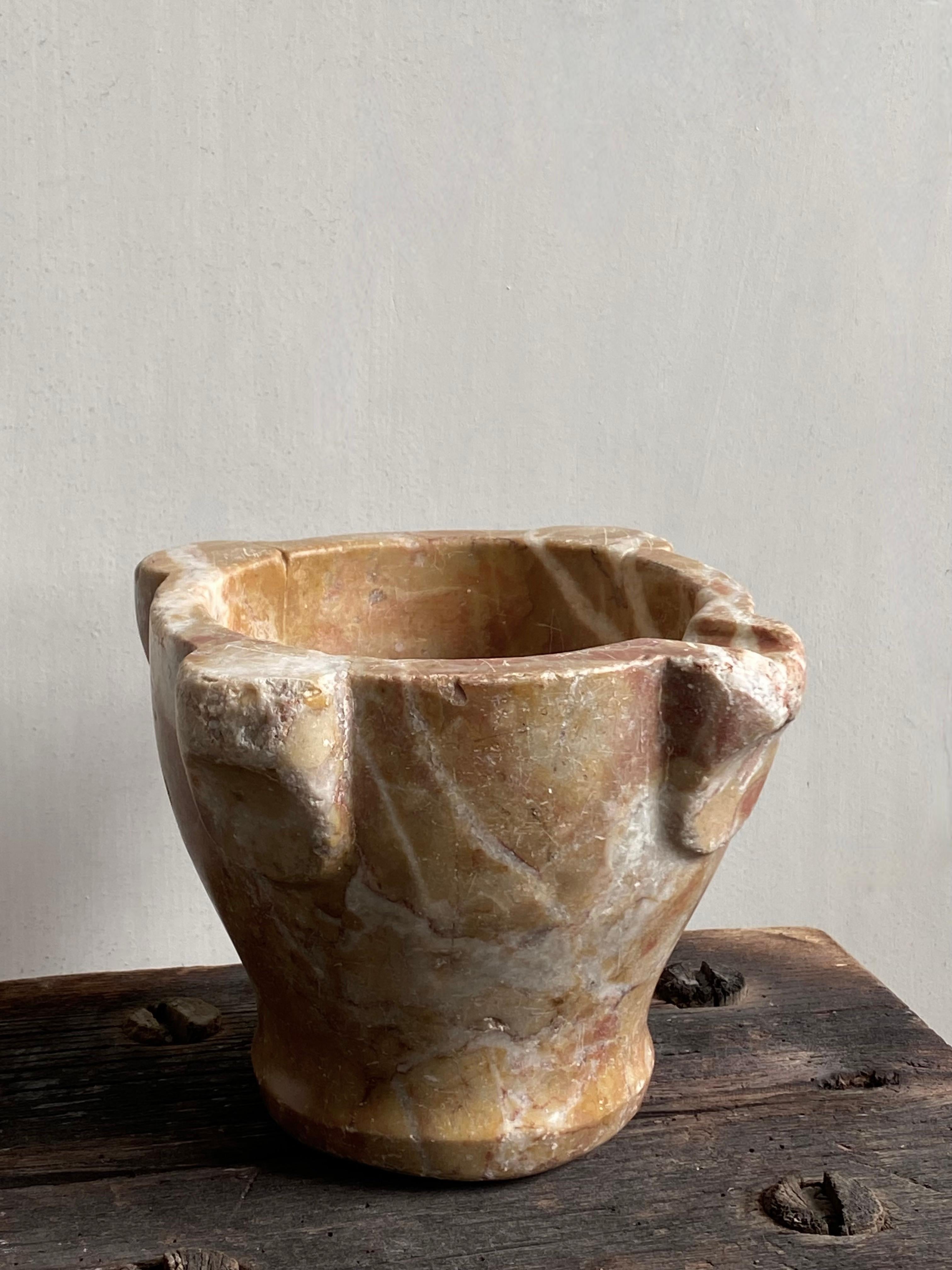 This 18th century Italian pharmacist's mortar is a unique piece of its kind.
The warm color of the marble type is rare and reflects the beautifully carved ears. An elegant representation of a utensil that has weathered through age and use.


Free