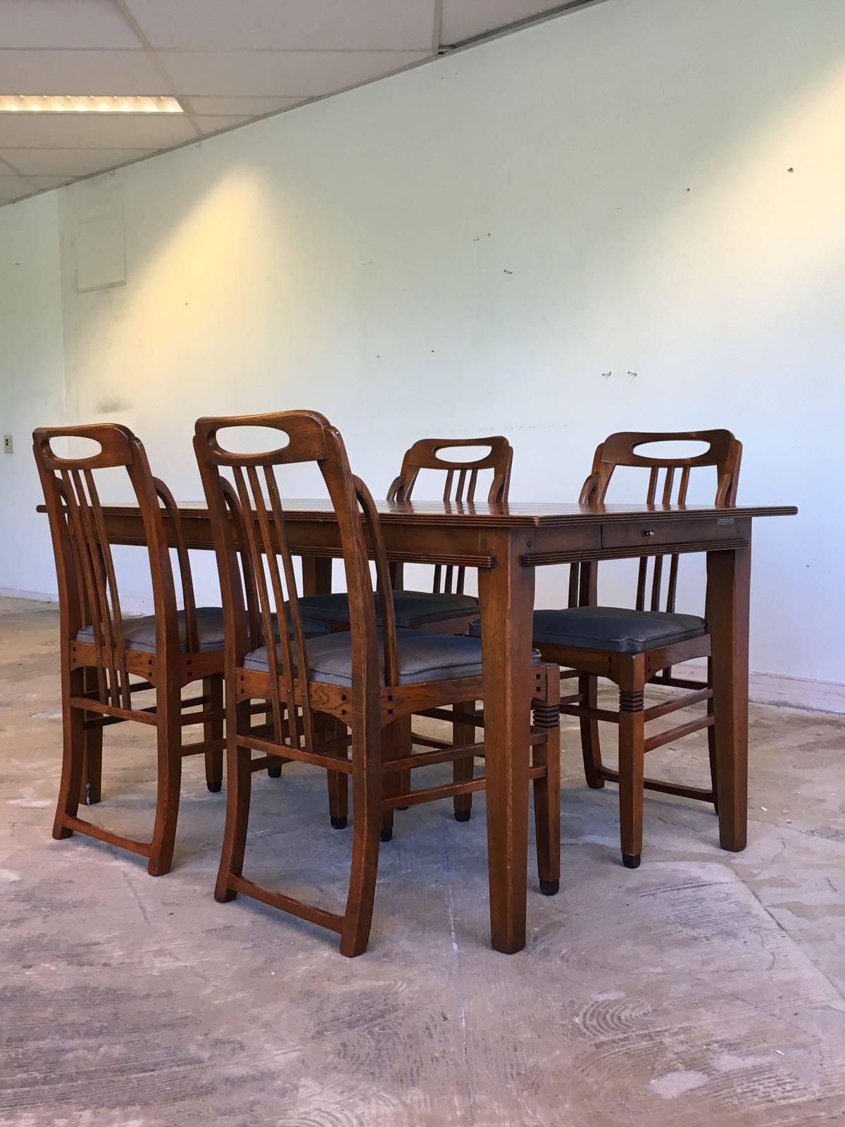 This wonderful dining room set was manufactured by (Frits) Schuitema & Zonen in the Netherlands. It features four exclusive Art Deco style chairs and a dining table with a drawer to the side. All of the pieces are sturdy and in a very nice