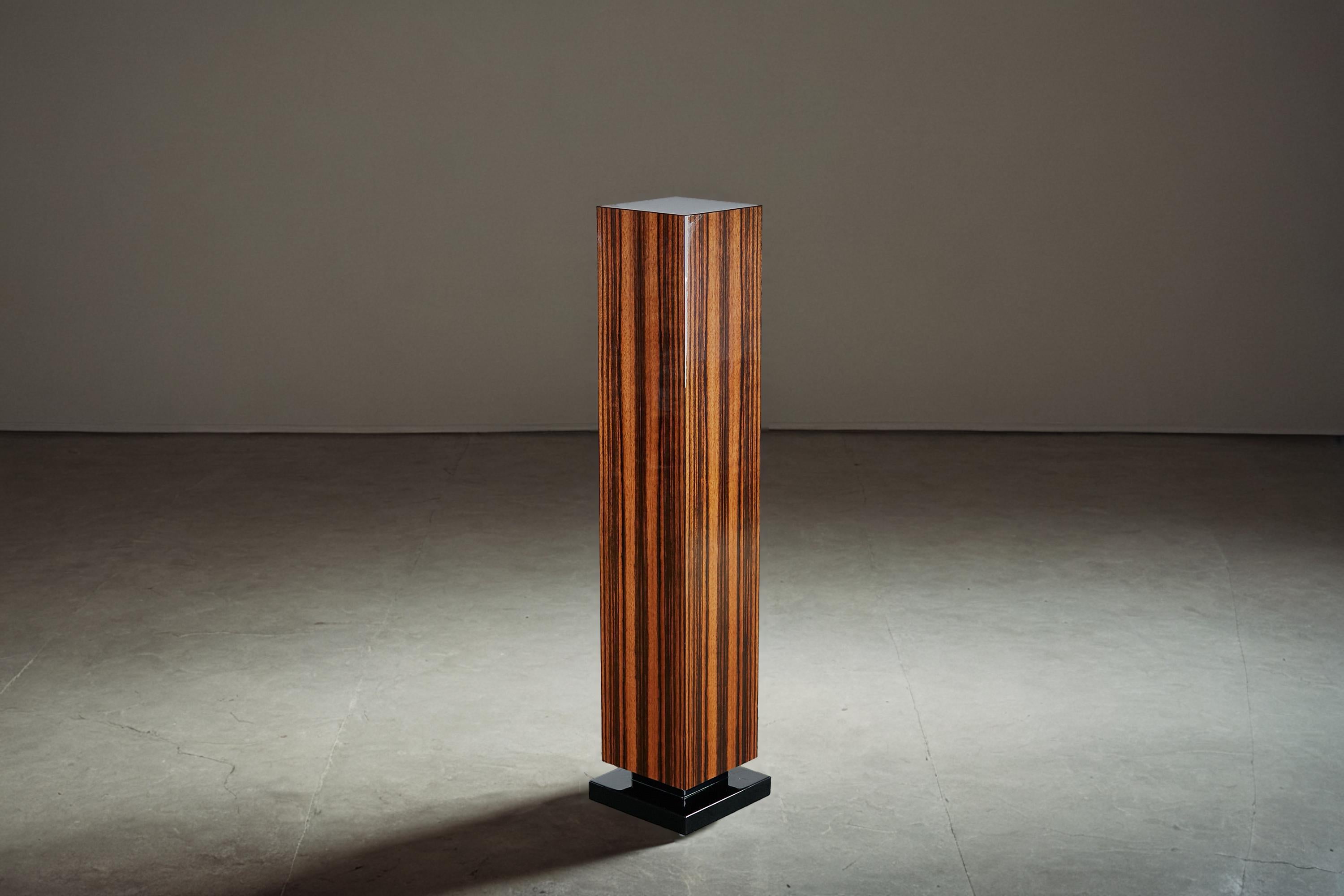 Notre élégant piédestal Art déco, d'une hauteur de 1,19 mètre, présente un placage Makassar clair avec une finition brillante. La base noire est également recouverte d'une laque piano très brillante, ce qui ajoute une touche de luxe à la pièce.

Ce