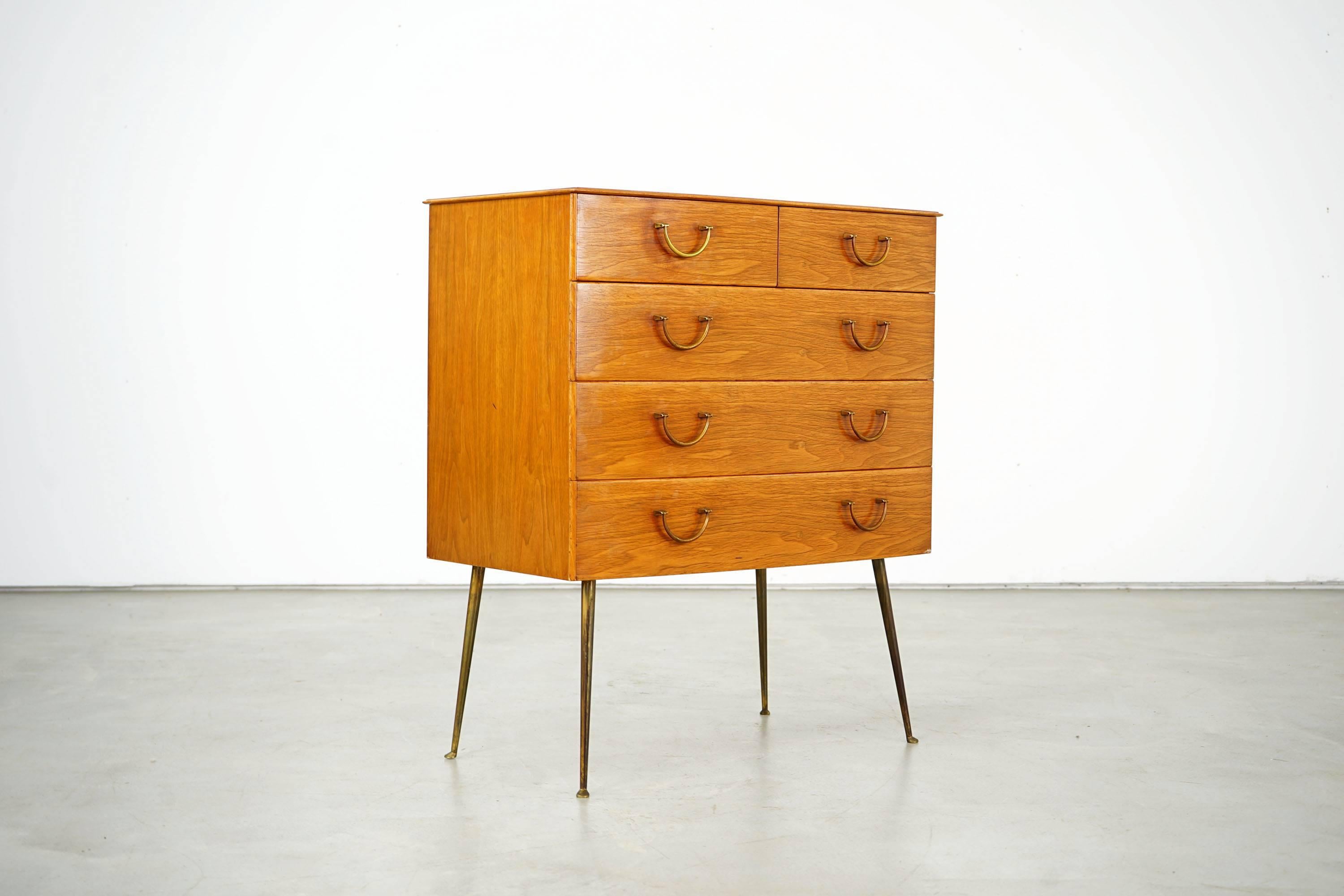 The exclusive walnut and brass bureau dates back to the late 1940s. Over time, brass handles and -feet developed a distinctive patina. Five drawers are available, four of which are suitable for cutlery. The bureau was elaborately made and is of high