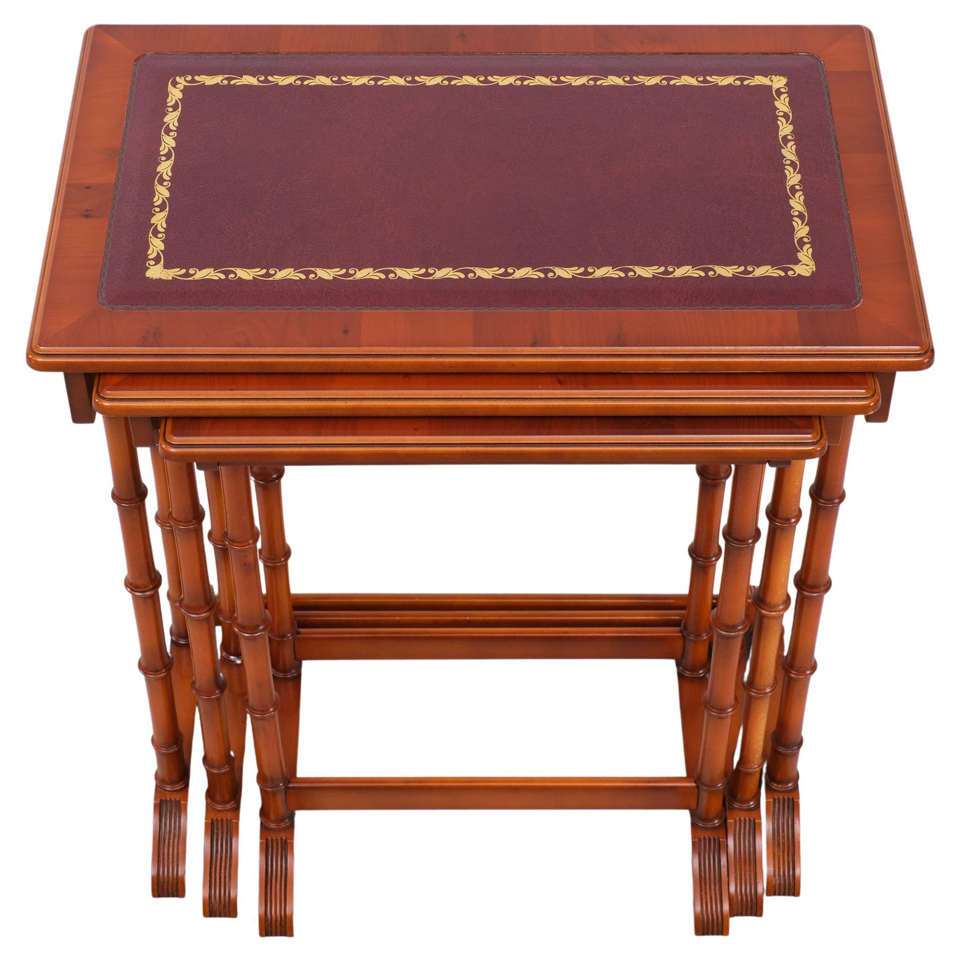 Superb Cherry wood Nesting table . Dark Red Leather. embossed Gold decoration .
Faux Bamboo legs .Hanging on one of each other . Top quality tables .Perfect condition. attributed to Reprodux Exclusive English furniture . 

Please don't hesitate to