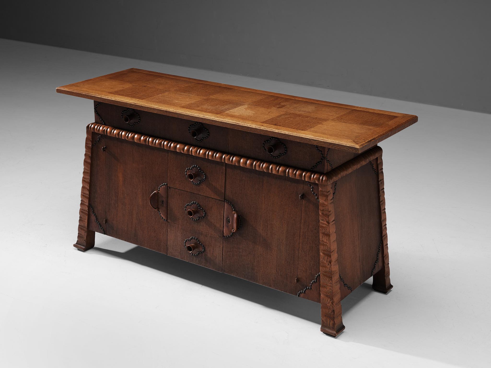 Ernesto Valabrega, cabinet, oak, metal, Italy, ca. 1935

This stunning cabinet shows the characteristics of Ernesto Valabrega's designs. The dynamic engraved corners that continue gracefully in the cabinet's feet, in combination with the carved