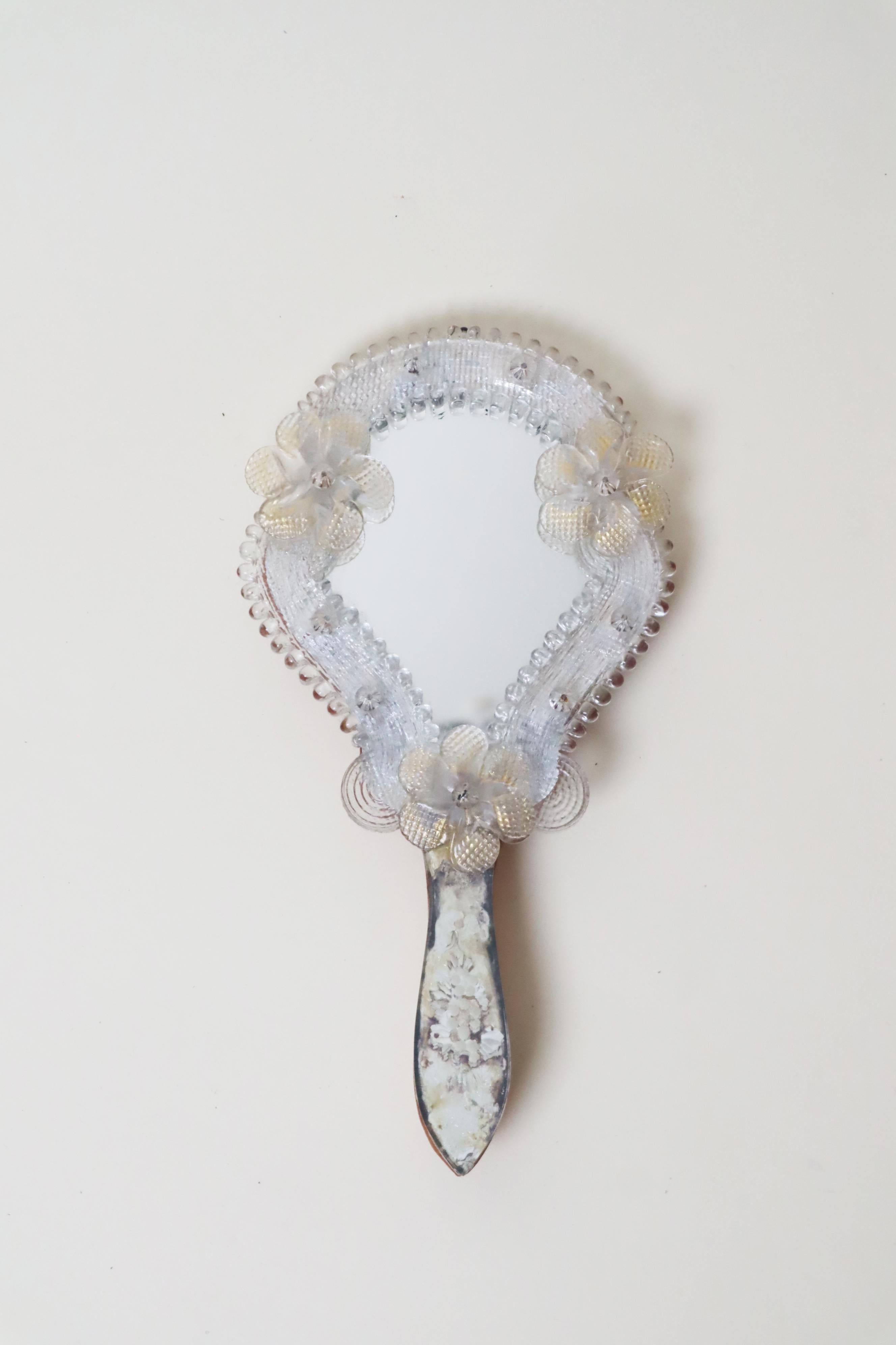 Il s'agit d'un miroir à main italien exclusif avec une patine étonnante. Ce joli miroir date des années 1950. Il a été fabriqué à Florence à partir du verre de Murano le plus fin. La poignée s'est estompée au fil des décennies, ce qui ne fait