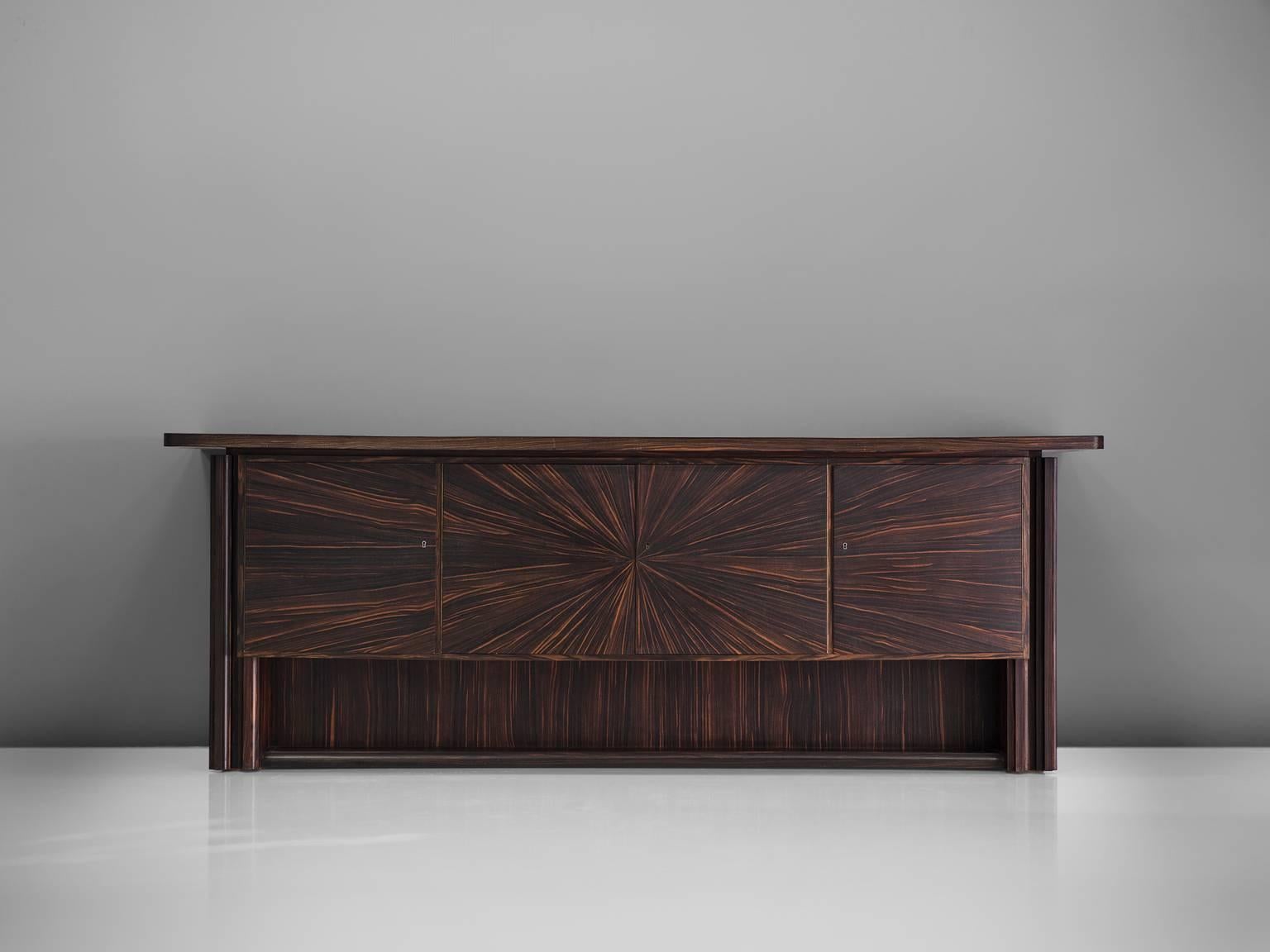 Sideboard, macassar, France, 1940s

A beautifully grained Coromandel / Macassar wood buffet. Completely restored and very impressive, this sideboard has clean cut shapes and a monumental look. The four front doors have a very inviting graphic