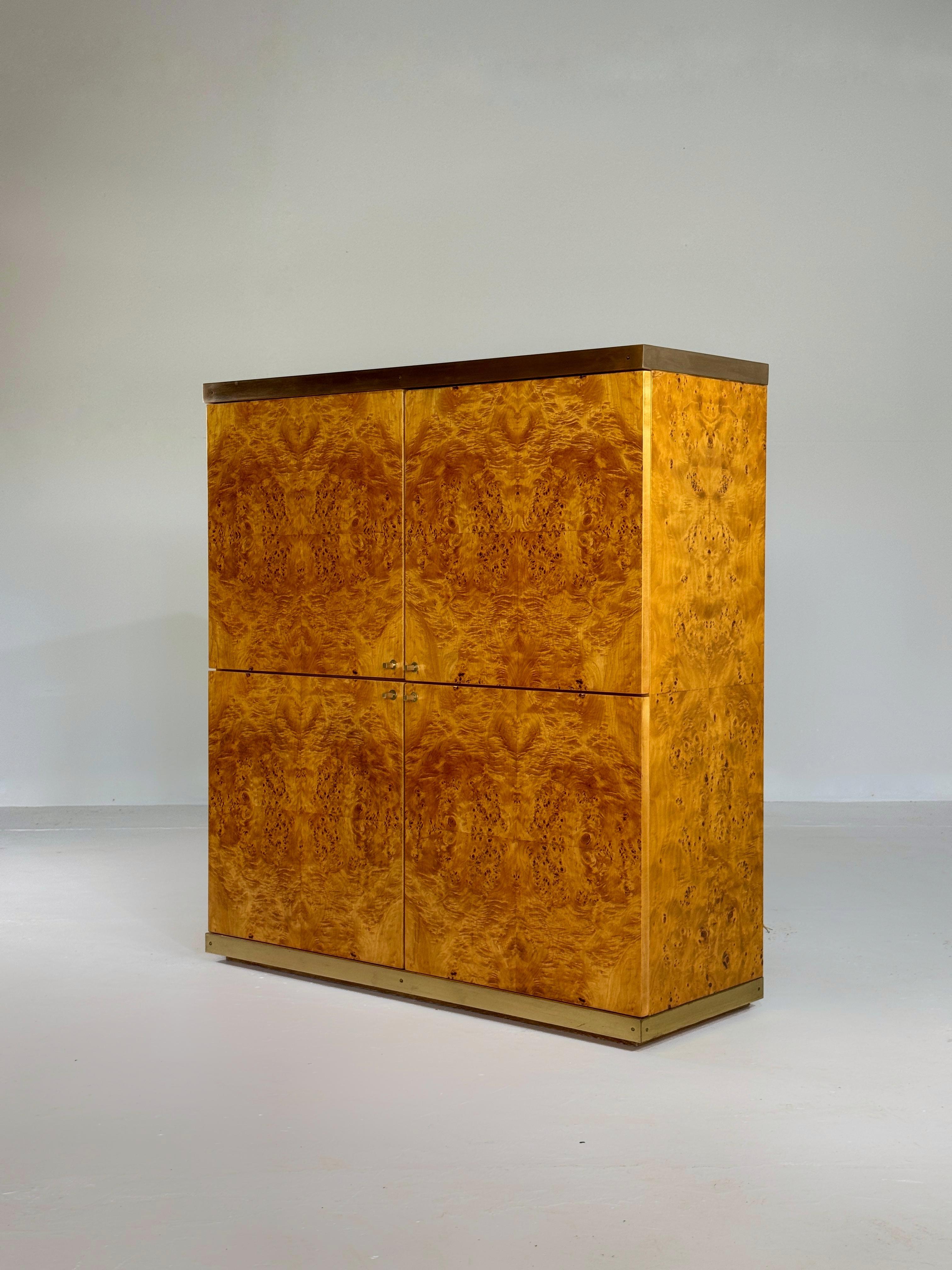 A really exclusive bar cabinet in high quality burlwood veneer and brass details.

This cabinet is completly restored and in absolute perfect condition.

Featuring 4 opening doors, both upper doors opening for an inside bar and both lower doors with