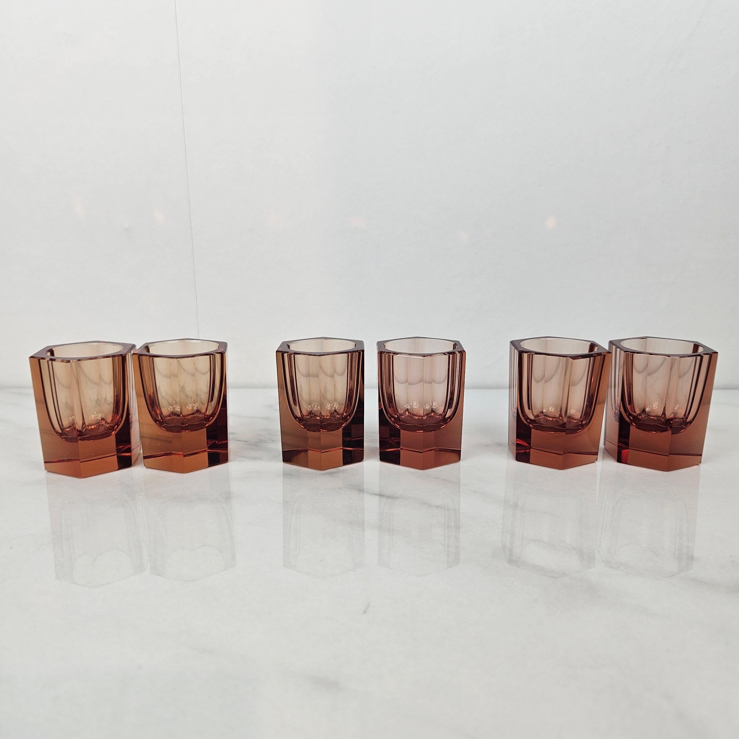 Cet ensemble exceptionnellement exclusif de six verres en cristal date des années 1920 et met en valeur l'élégance géométrique audacieuse du début de l'Art déco. Fabriqué en cristal épais de haute qualité, d'une teinte ambrée profonde, chaque verre