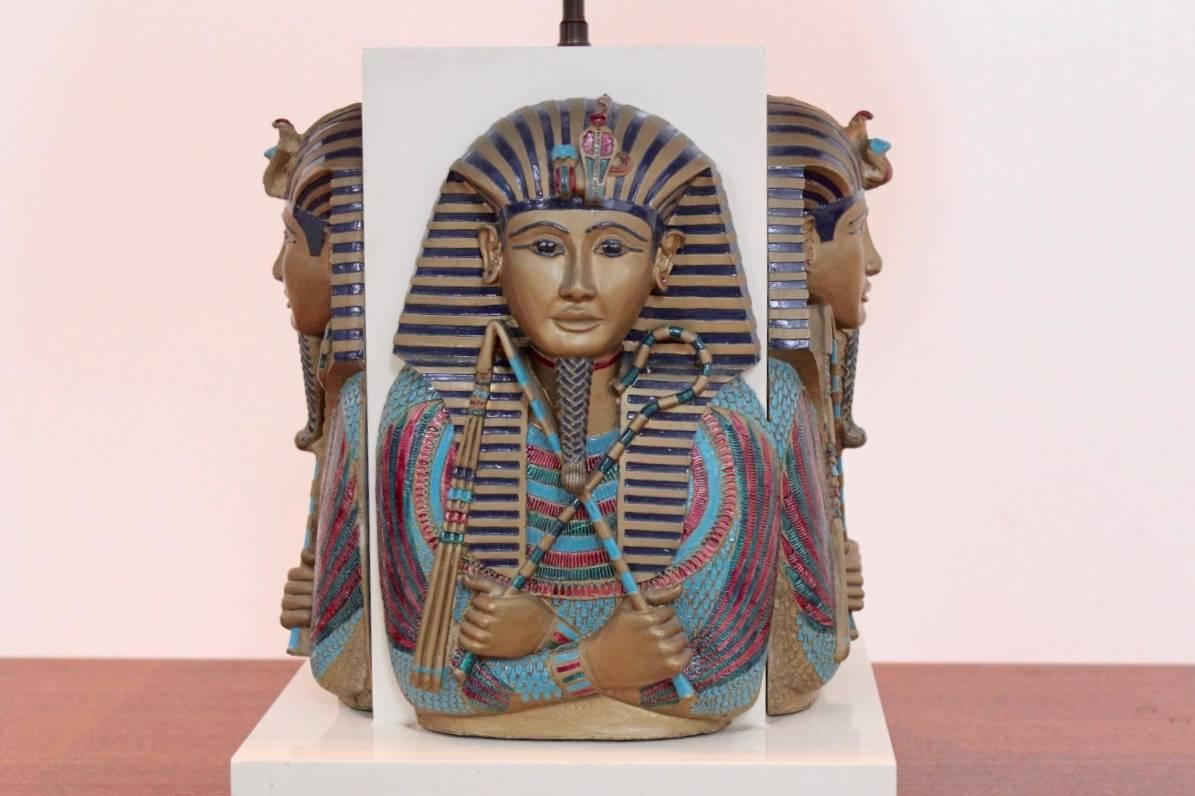 Exclusive, unique and exotic Toetanchamon table lamp from the 1950s and made in France. This luxurious lamp features four Pharaoh masks on each side very detailed and beautiful sculptured and painted in original colors. Very heavy table lamp coming