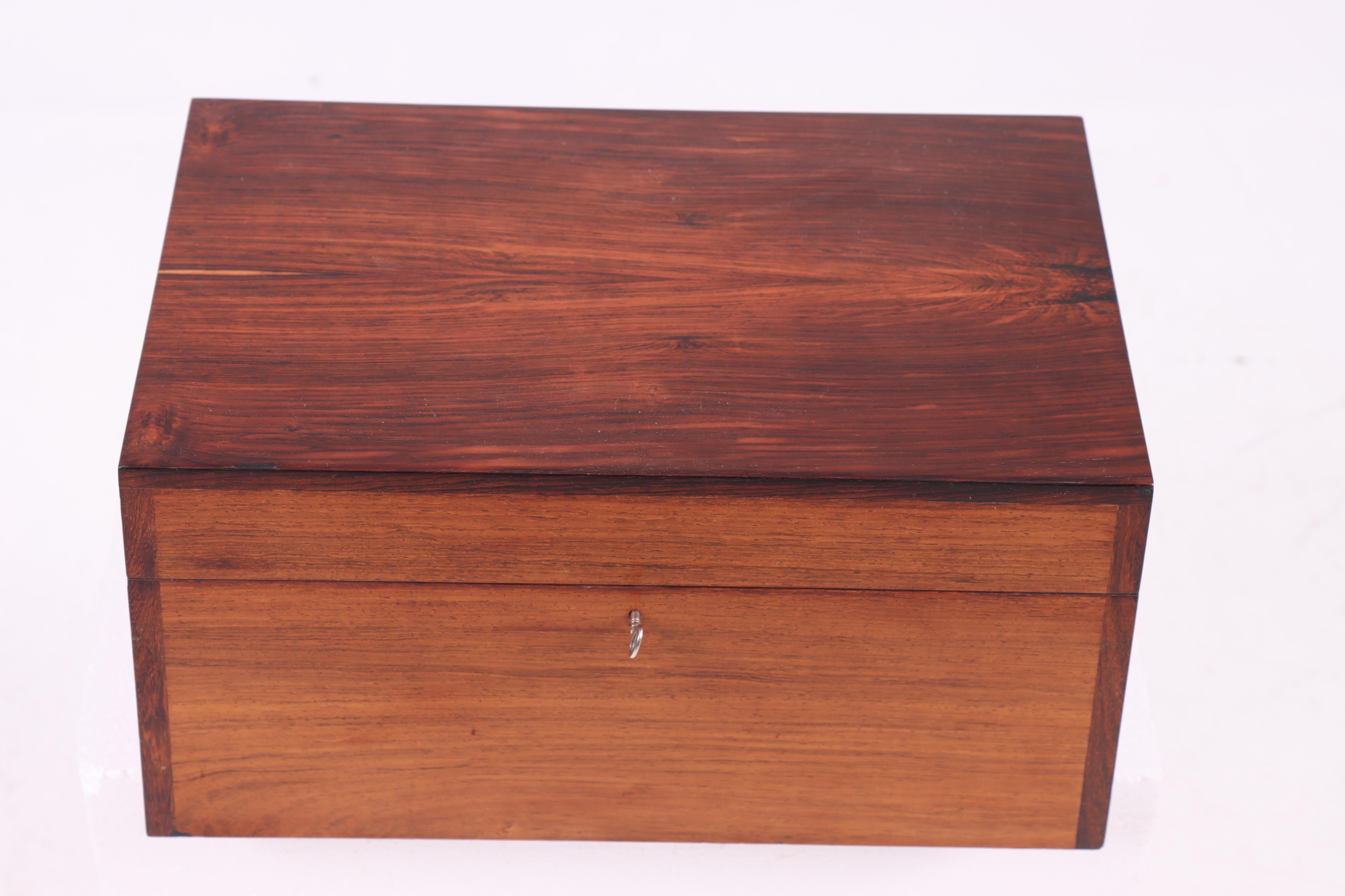 Esta hermosa caja está meticulosamente elaborada con auténtico palisandro, lo que le confiere un color cálido y rico con un brillo natural. El palisandro es conocido por su durabilidad y sus bellas vetas, que hacen que cada caja sea única.

Perfecto