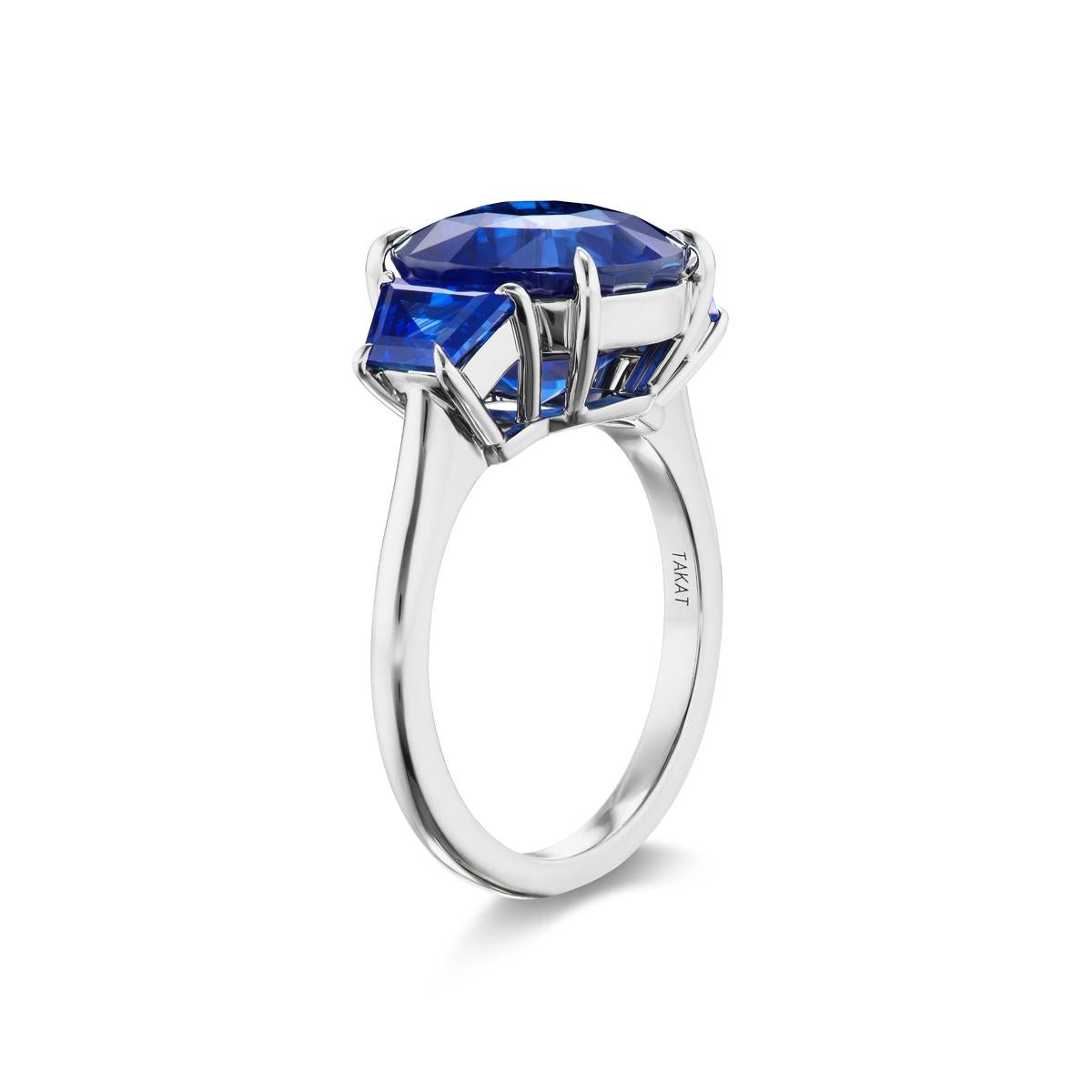 This ring features a 3-stone setting with a Blue Sapphire as the center piece, the shoulders of this ring are adorned with trapezoid cut deep blue sapphires. An equally gorgeous solitaire band completes this classic Sapphire ring in an 18k White