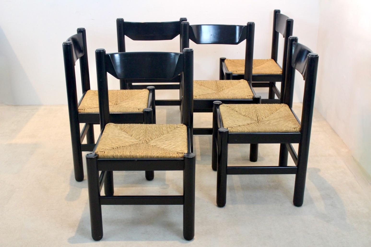 Very practical and original mid century dining table with six matching chairs attributed to Vico Magistretti, produced by Cassina (attr.). Made in Italy, dating from the ‘60s. This black solid beechwood table comes with very comfortable chairs with