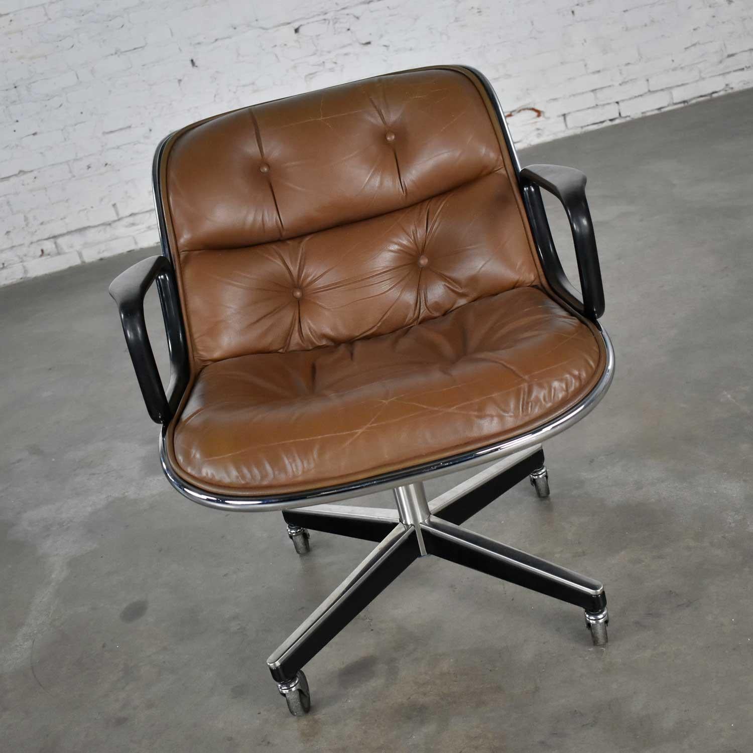 Handsome executive chair by Charles Pollock for Knoll. Comprised of brown leather, aluminum band, chrome shaft, black plastic arms, and a 4-prong stainless base with casters. Wonderful vintage condition with some tightening of the buttons as they