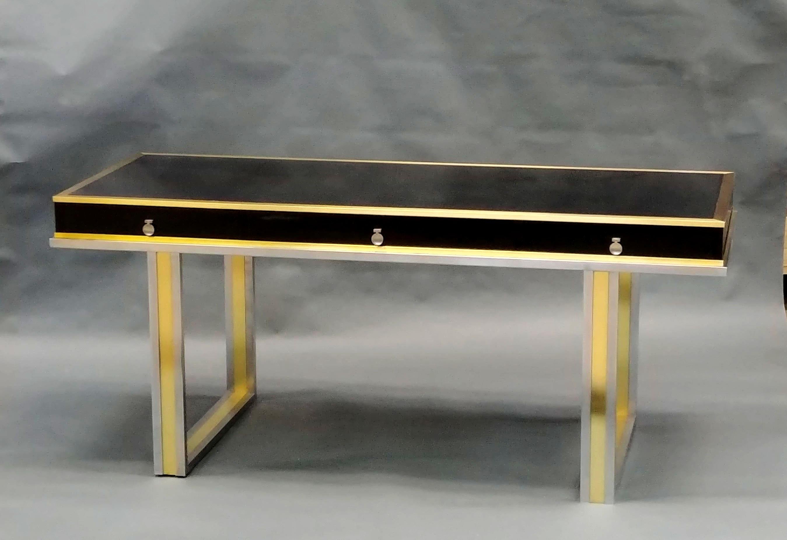 Executive black laminate three-drawer desk, with alternately, polished nickel and brass frame. Hardware is brass as well.