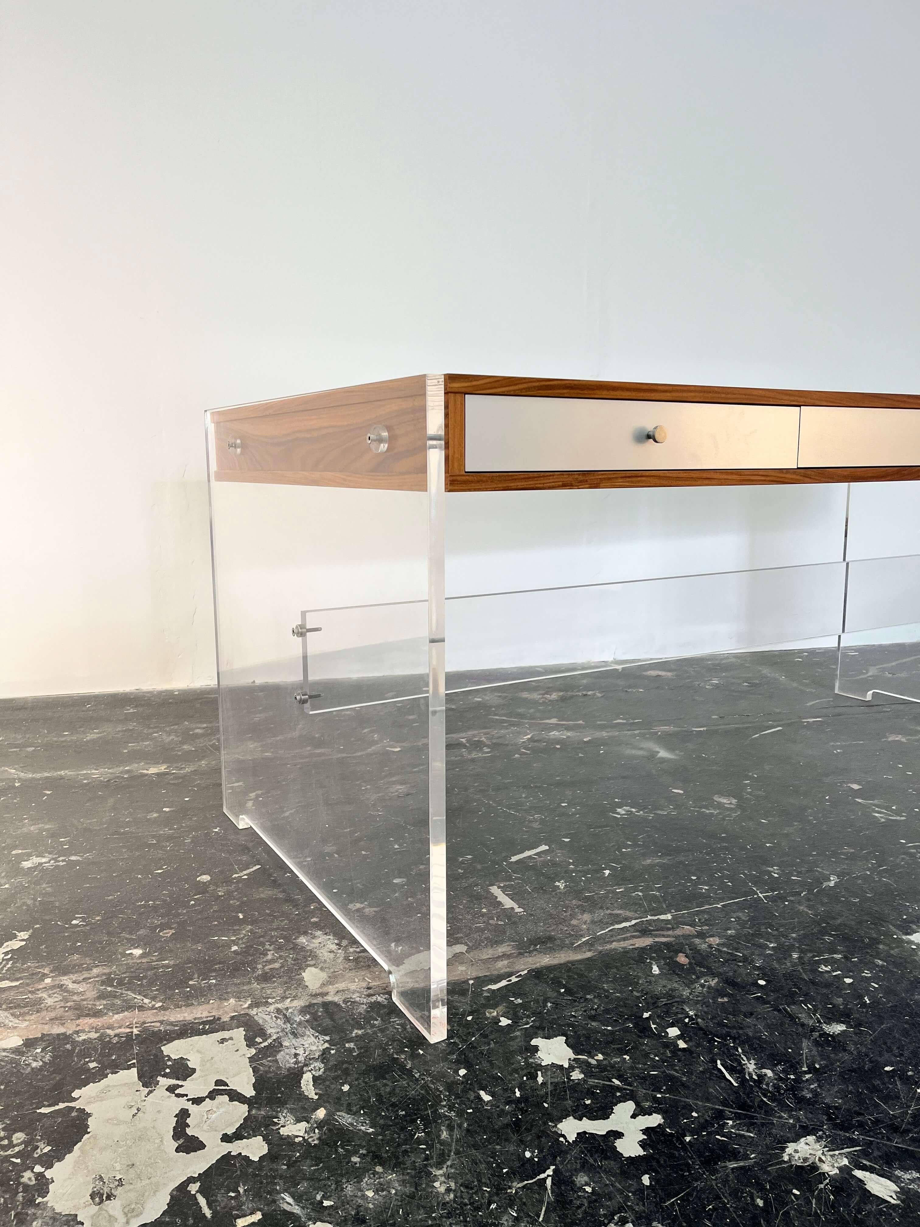 Poul Nørreklit desk model GP 160 by Georg Petersens Møbelfabrik, Denmark

This is a rare and collectible lucite and rosewood desk. Lucite slab sides with beautifully grained Rosewood case, lucite spacers, aluminum drawer fronts, and nickeled brass