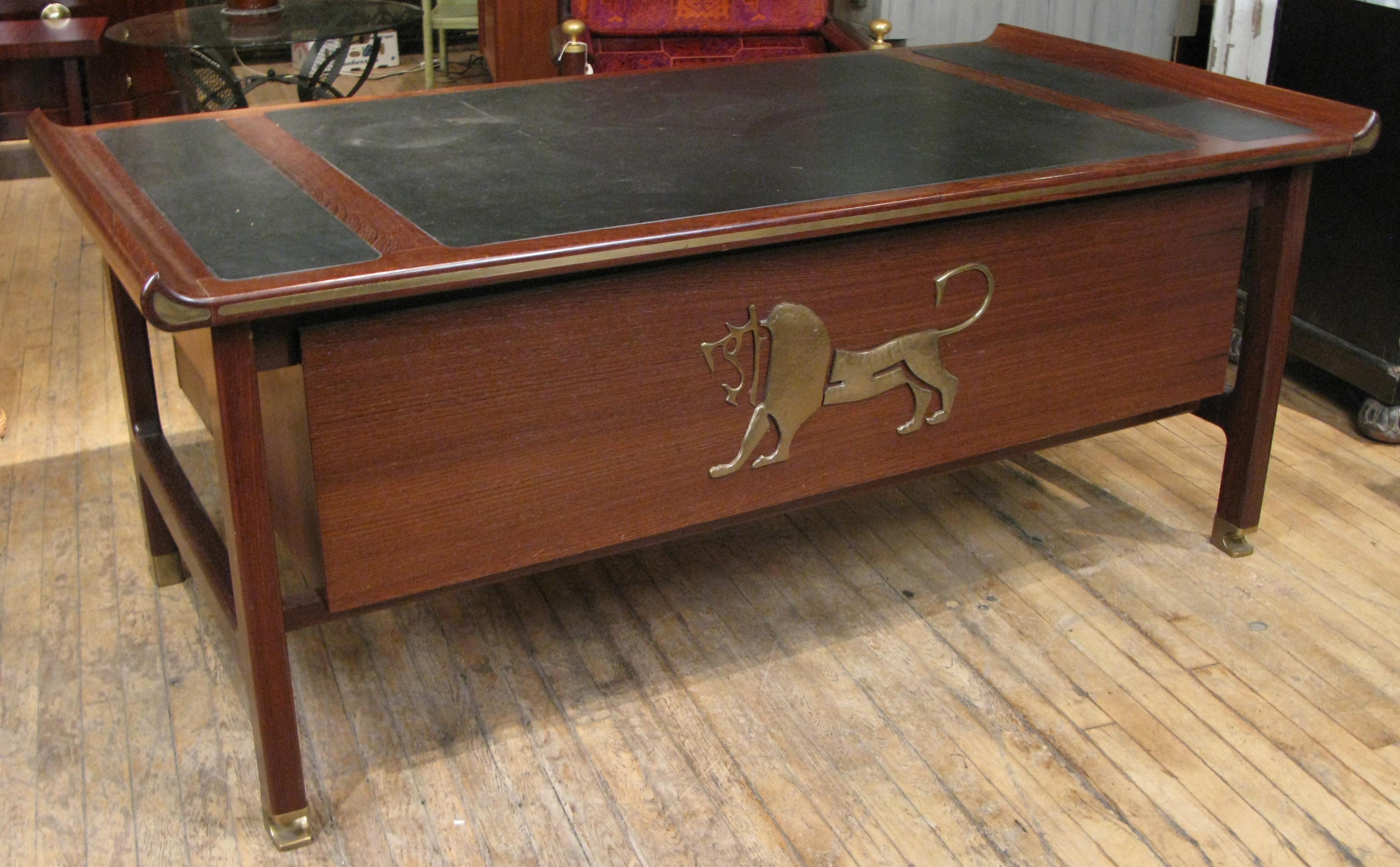 a rare and impressive executive desk designed by Ib Kofod Larsen from his Megiddo Collection inspired by his travels in the mid-East, the desk is made in solid Wenge with inset brass details, solid brass feet and hardware. on the front of the desk