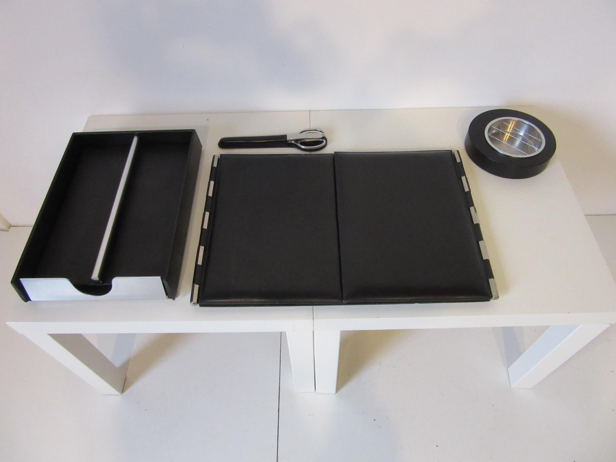 A matching four piece high quality black leather desk set containing large opening desk pad, leather wrapped ashtray, scissors, letter opener with holder and a file tray with lid. Used in a up coming movie with Anne Hathaway, Mark Ruffalo and Tim