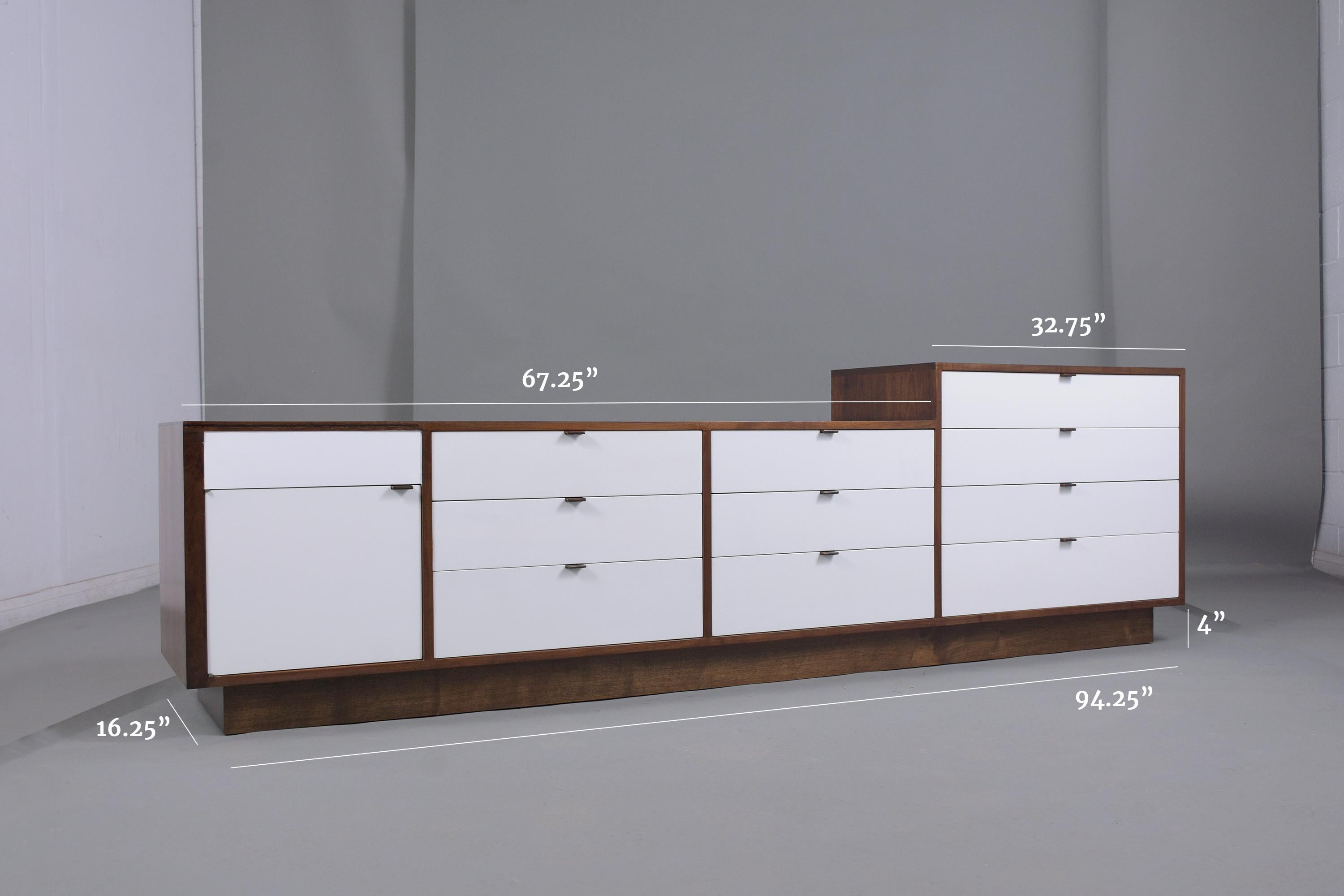 This mid-century 1960s executive credenza attributed to Milo Baughman is hand-crafted out of walnut wood and has been professionally restored by our craftsmen. The dresser is newly stained in walnut and white color combination with a lacquered
