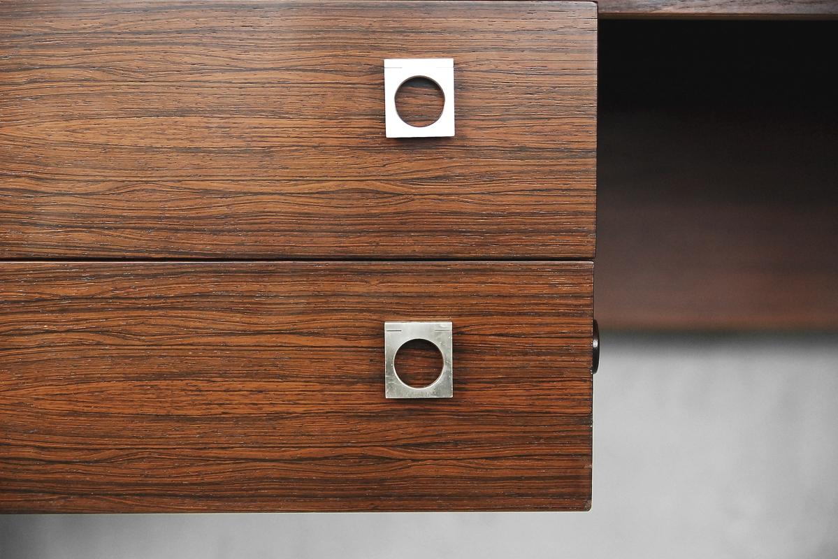 This desk was designed by Arne Vodder for Sibast in Denmark during the 1960s. The desk is made from rosewood. The piece features 3 drawers on one side and 4 drawers in the other side, with brushed stainless steel handles.

Arne Vodder was born in