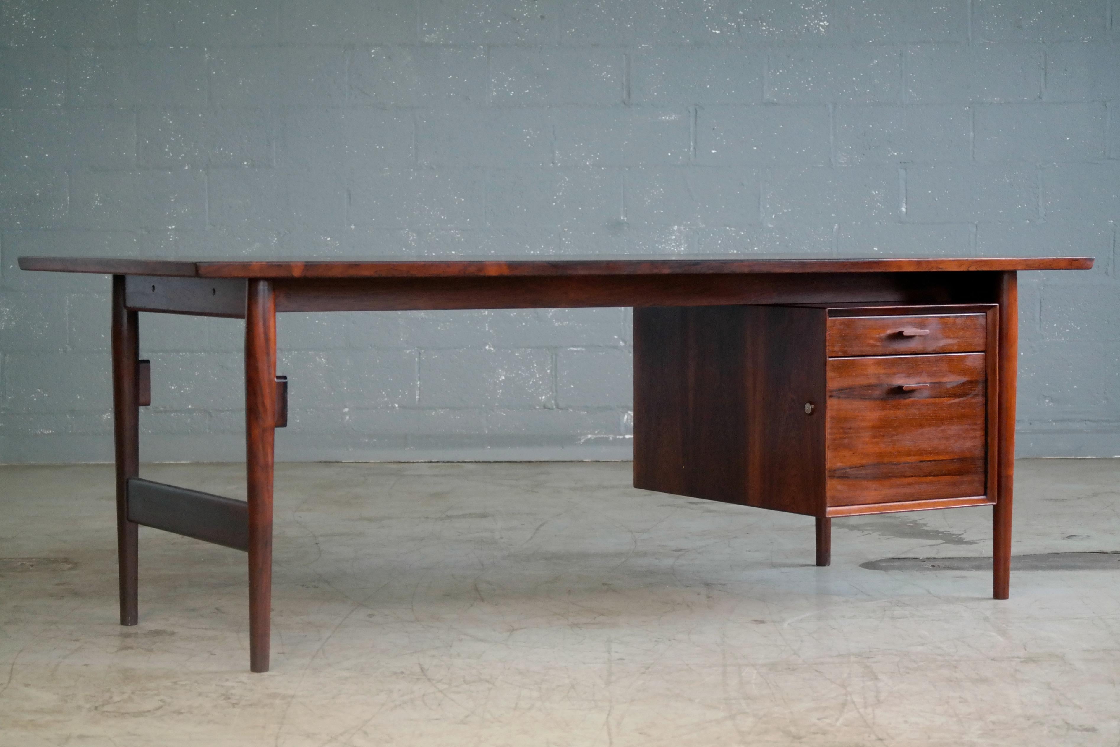 Magnificent large Danish midcentury executive desk in rosewood designed by Arne Vodder in the 1950s and manufactured by Sibast of Denmark. Thick solid edges throughout and nice color and grain. Some minor fading and very minor scratches and dings to