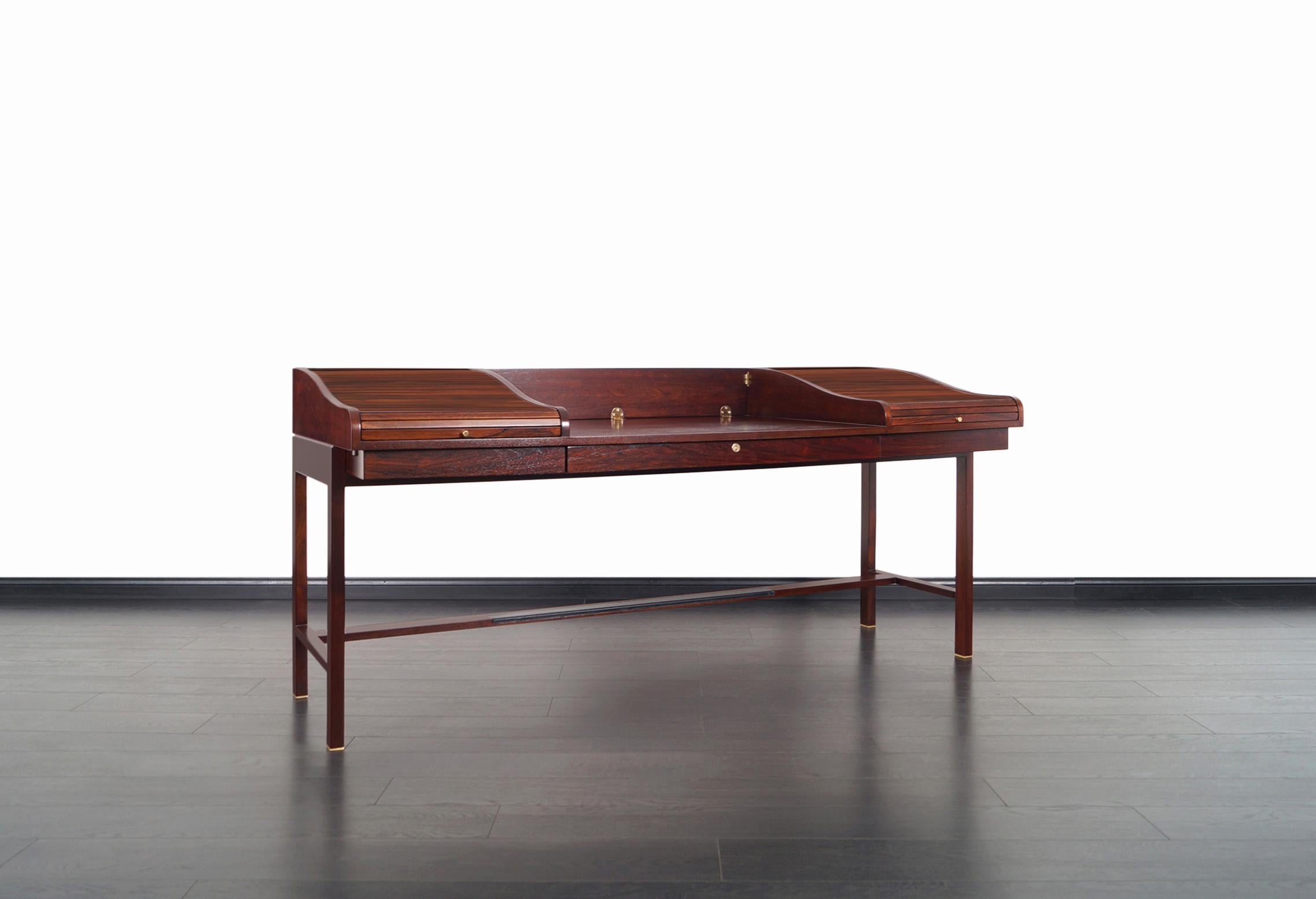 Elegant vintage executive desk designed by Edward J. Wormley for Dunbar in the United States in 1957. This iconic model #452 desk features a solid walnut frame and writing surface with a hinged panel at the back that drops, allowing it to convert to