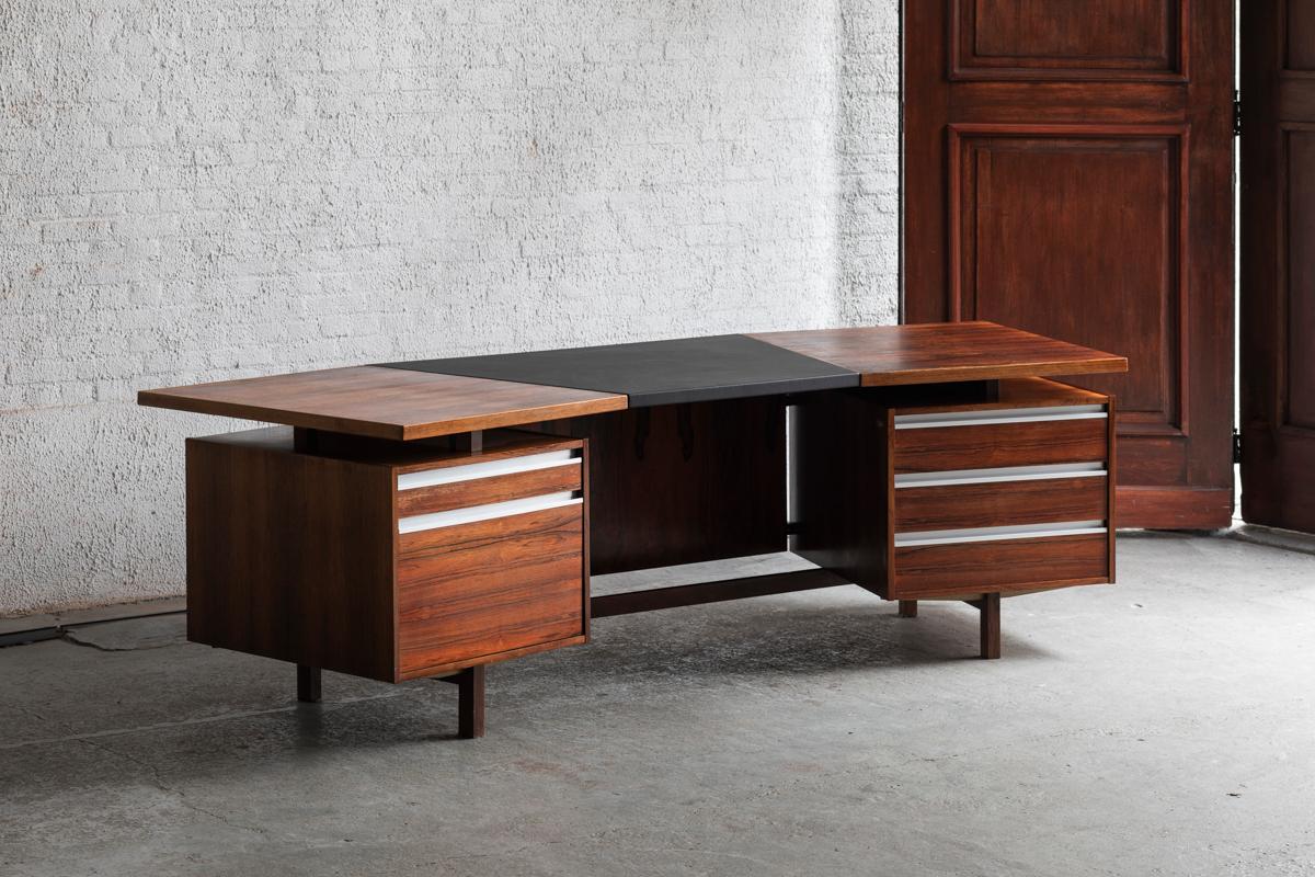 Executive writing desk designed by Kho Liang Ie and produced by Fristho in Holland around 1960. The desk top is made out of rosewood veneer and is finished with a sheet of skai leather. It contains drawers and a document storage cabinet. Keys are