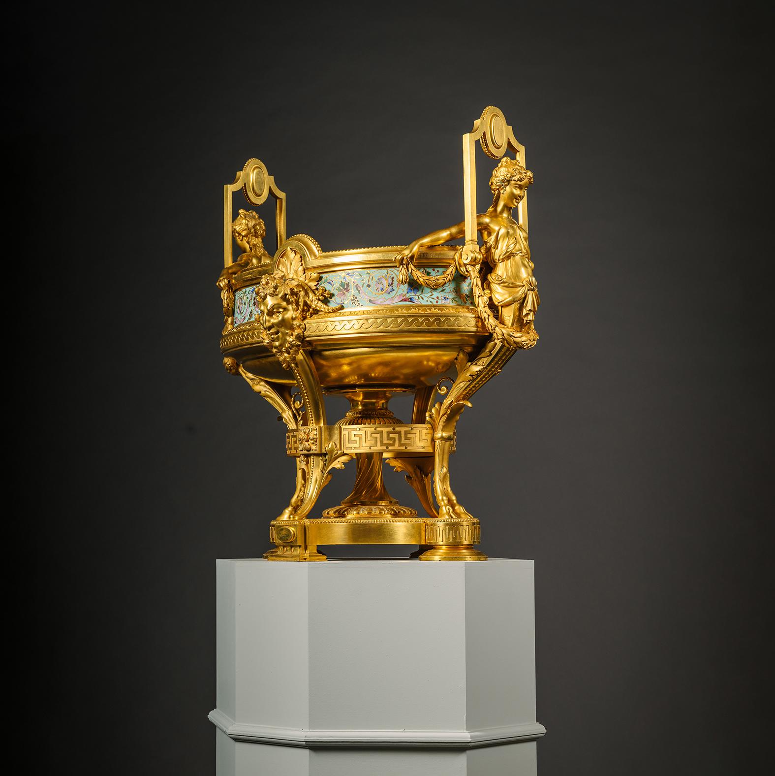 Jardinière d'exposition en bronze doré et émail champlevé, par George Servant, Paris. 

Cette magnifique jardinière 'Louis Seize' est conçue dans le style Néo-Grec. Les poignées sont superbement sculptées en bronze doré et ciselé, représentant des