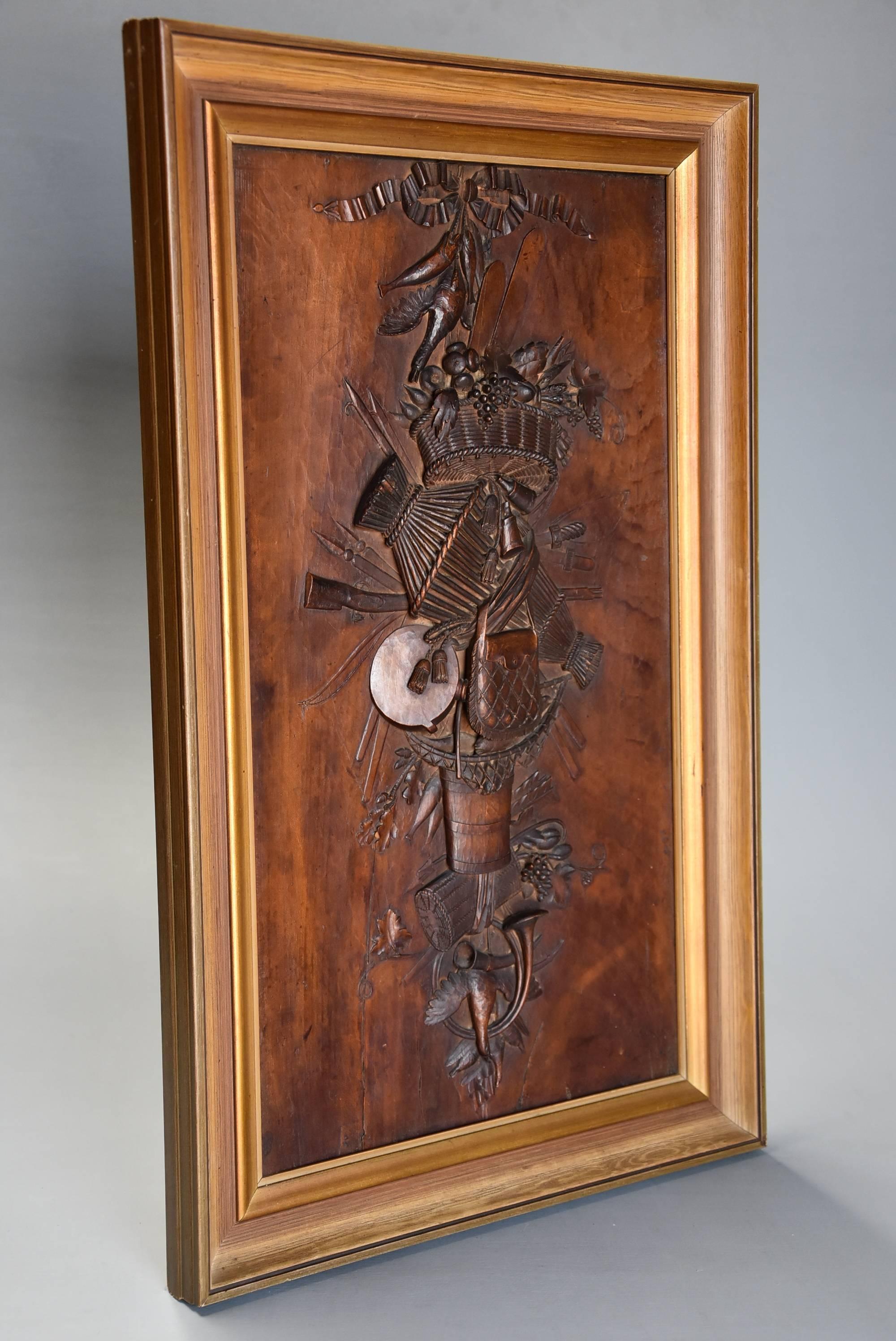 An exhibition quality finely carved mid-19th century Continental fruitwood trophy carving presented in a frame.

This superbly carved panel consists of various 'trophy' and hunting related articles such as a carved ribbon, fish, birds, finely