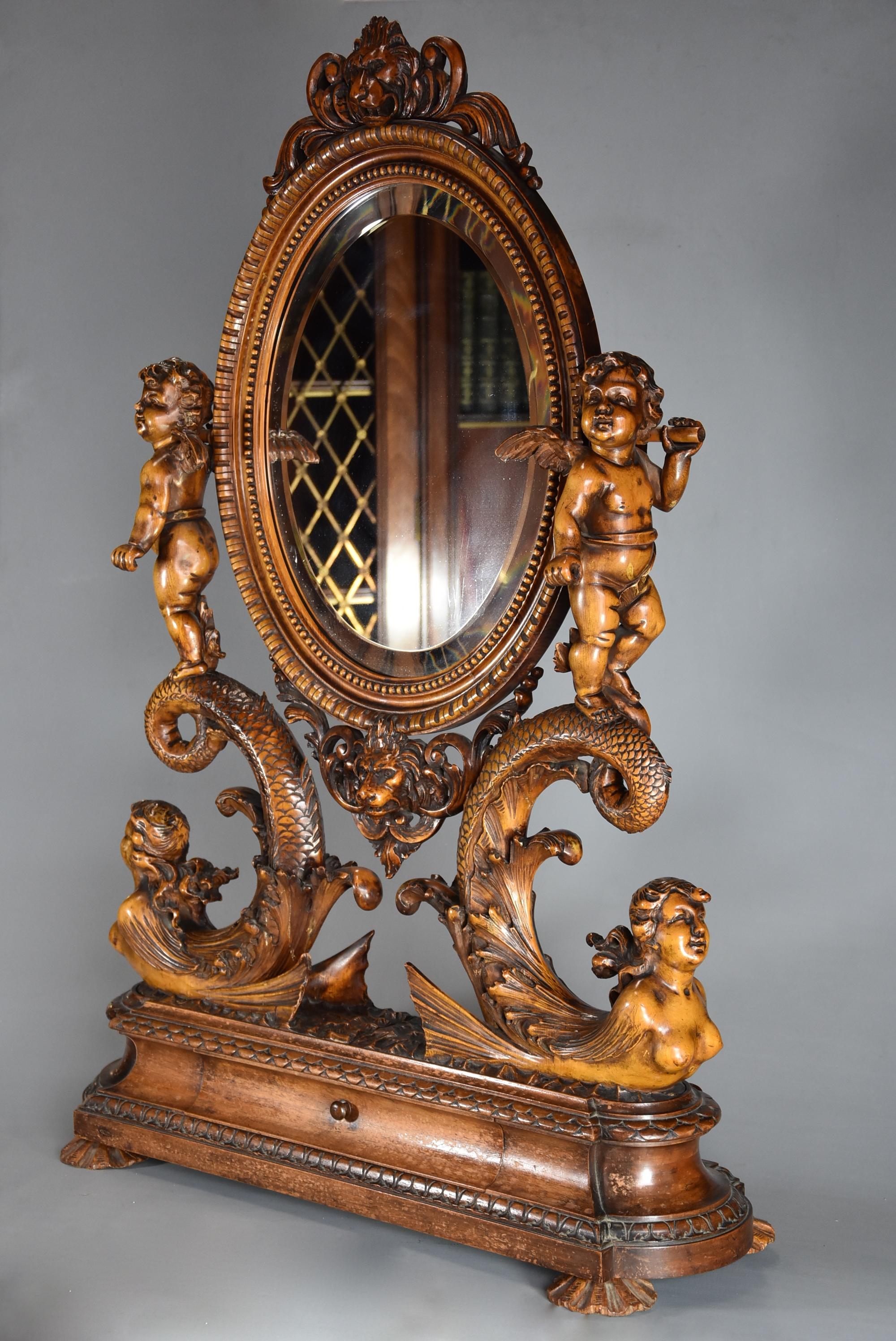 An exhibition quality superbly carved mid-19th century Italian lime wood table mirror.

This table mirror consists of an oval mirror, the oval lime wood frame of superb ball bead and other carved decoration with lion mask to the top and bottom