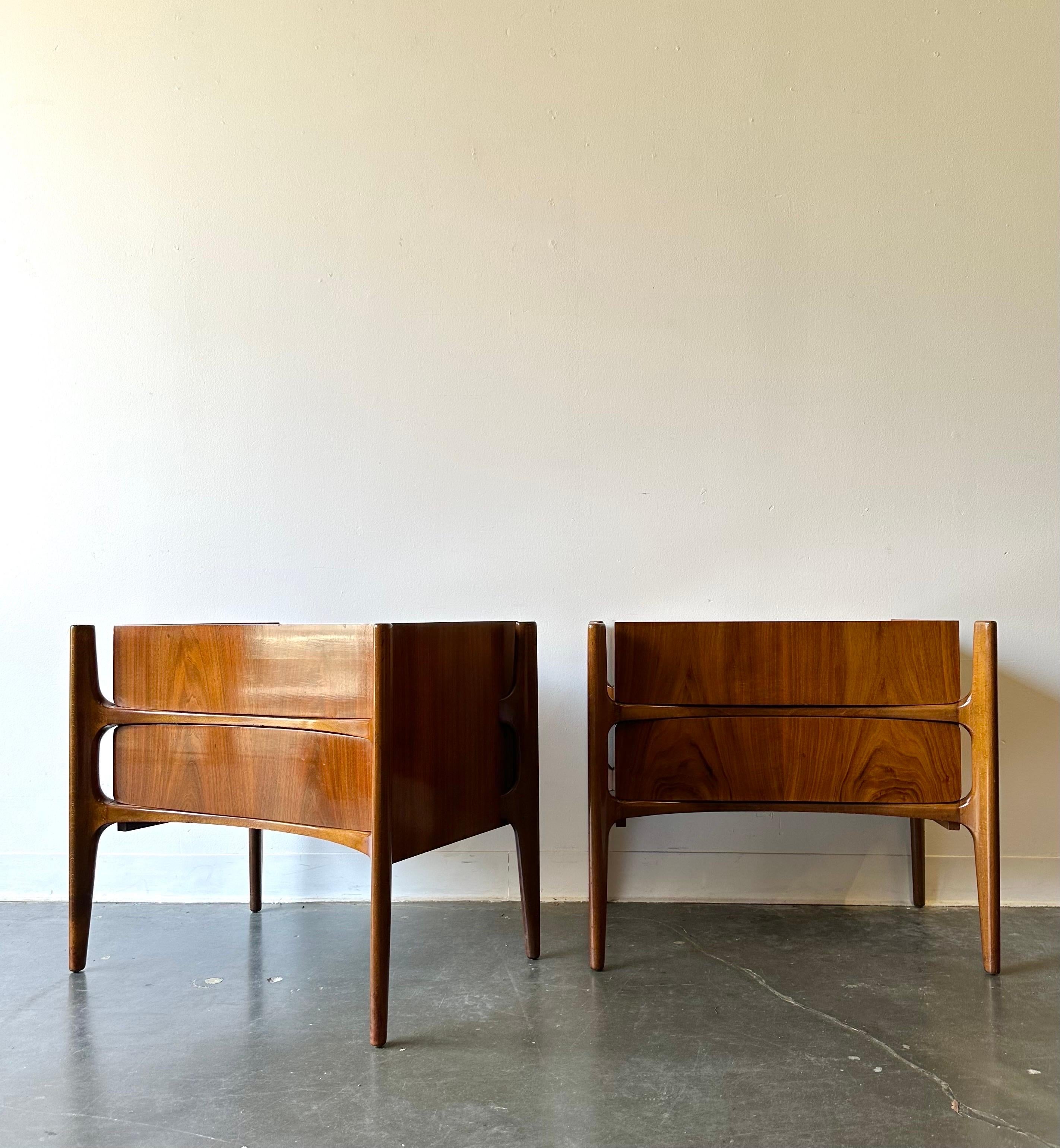 Highly sought after Exoskeleton nightstands by Designer William Hinn circa 1960.

Stunning set of walnut two drawer night tables. 
Curved front, exoskeleton frame, and beautiful grain.

Dimensions:

23