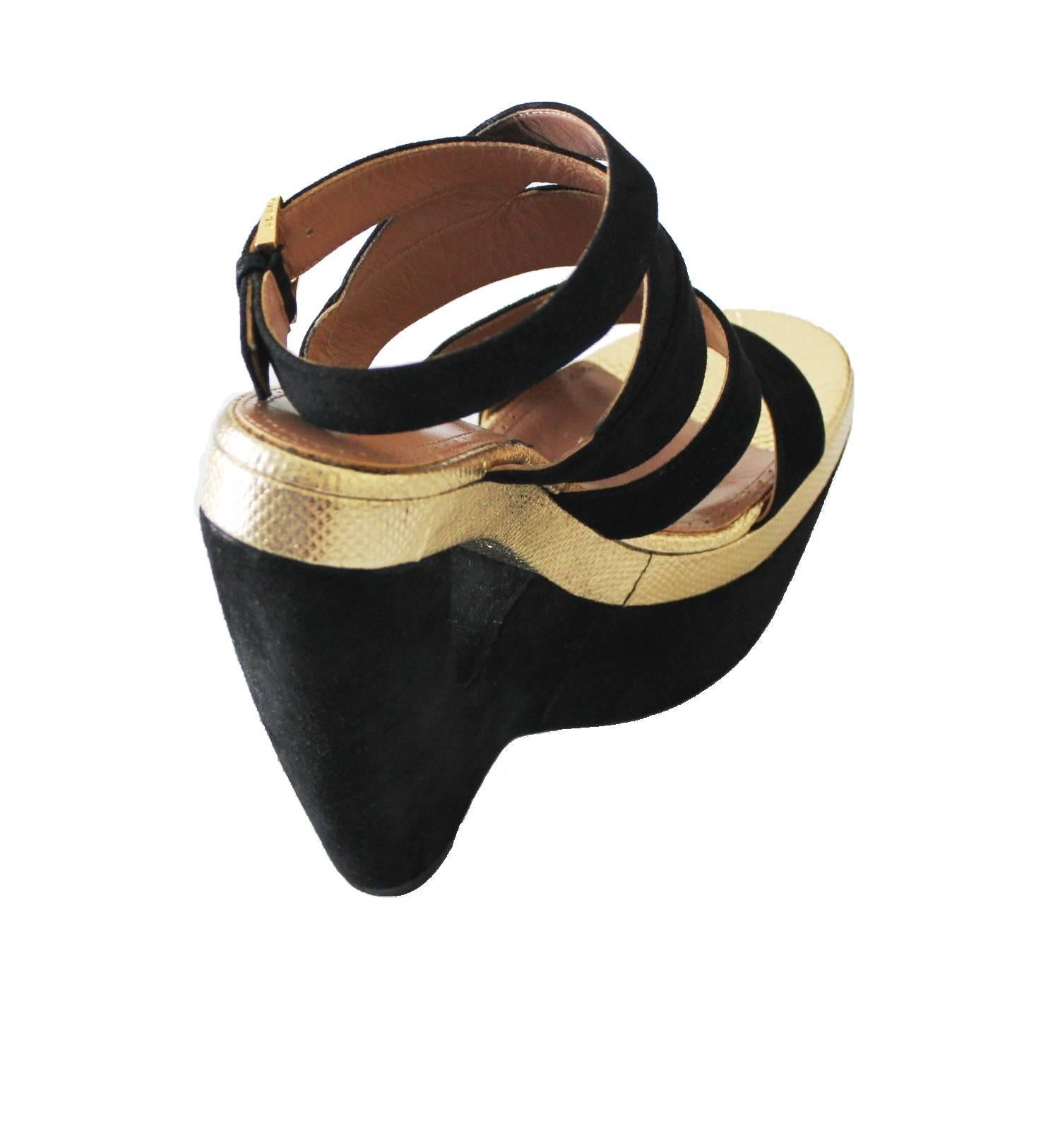 An AZZEDINE ALAIA classic signature piece that will last you for years
This gorgeous pair of wedges made out of finest black suede with cut-out wedge heel
Accented with real beautiful golden lizard leather
Golden closure discreetly engraved with