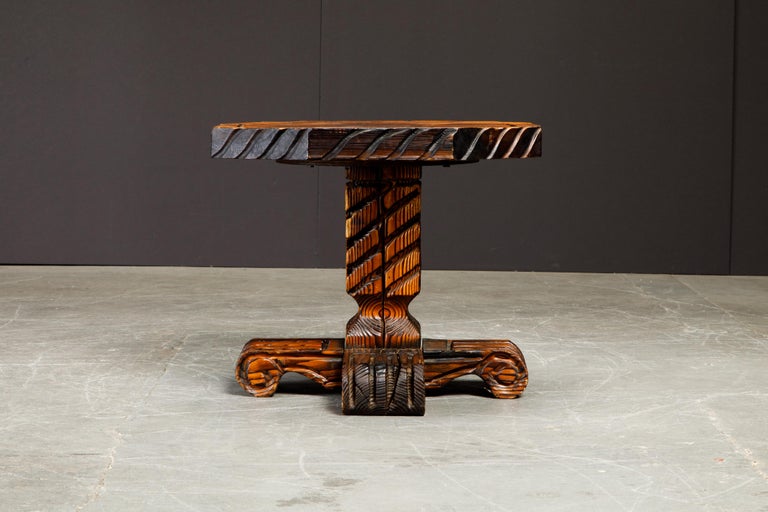 This ornately crafted side / occasional table with carved exotic details are a testament to William Westenhaver's Modern rustic creations. Influenced by Polynesian natives sculpting their ancestral deities in to wood furnishings, Westenhaver fused