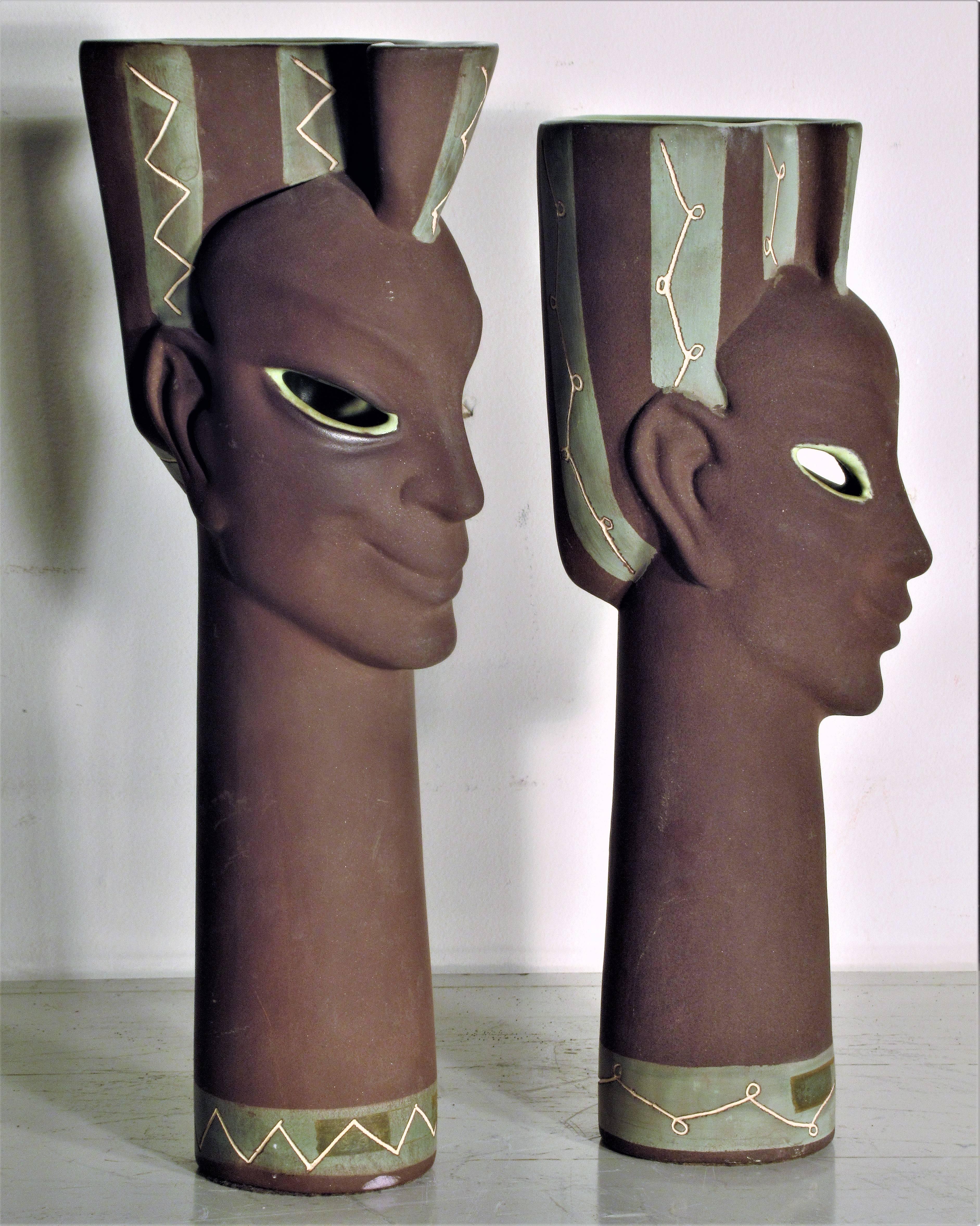 Two ceramic high style exotic male and female head sculpture vases with incised detailing and polychrome glazing. Larger figure measures 15 inches high x 5 1/2 inches wide x 5 inches deep - smaller figure measures 14 inches high x 4 1/2 inches wide