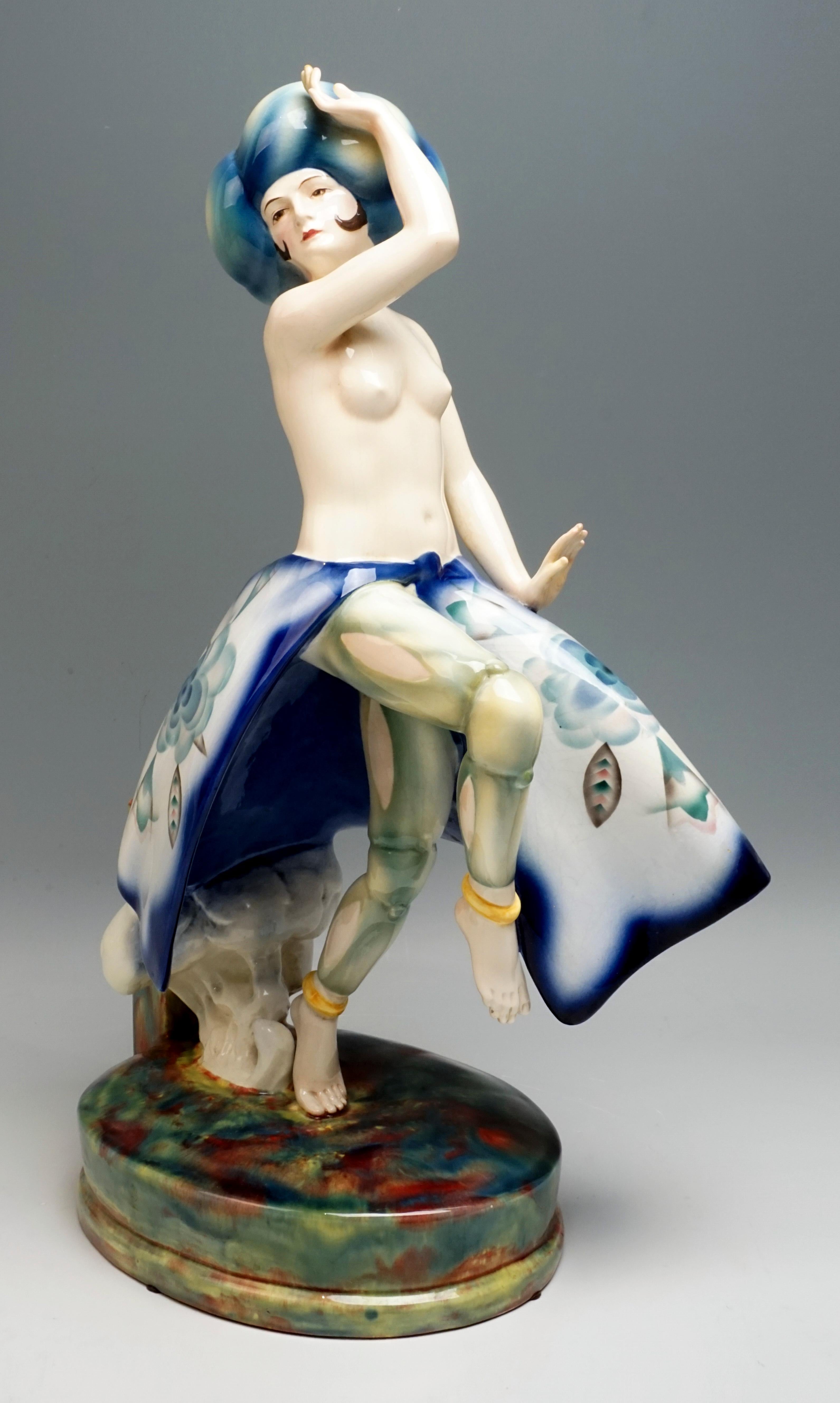 Very rare large Art Deco Goldscheider ceramic figure, circa 1930

The exotic dancer wears a large blue turban, her upper body is bare, underneath a voluminous skirt with a high slit at the front and an abstract floral decoration that looks like a