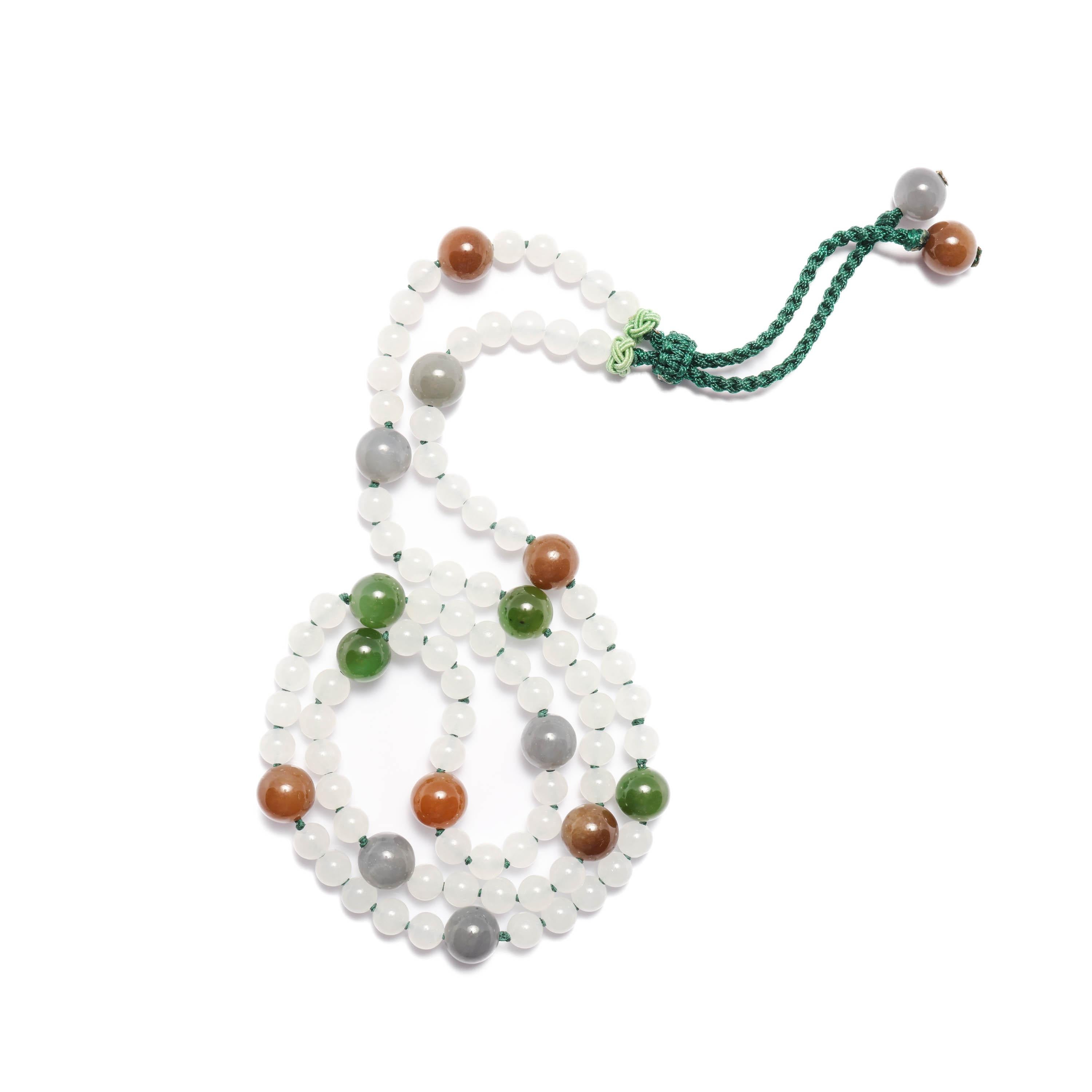 This gorgeous handmade necklace looks to be a strand of fine jadeite jade; the high translucency of the beads, the rich and varied coloring; all traits we associate with jadeite. But these beads are natural and untreated nephrite jade. Typically, we