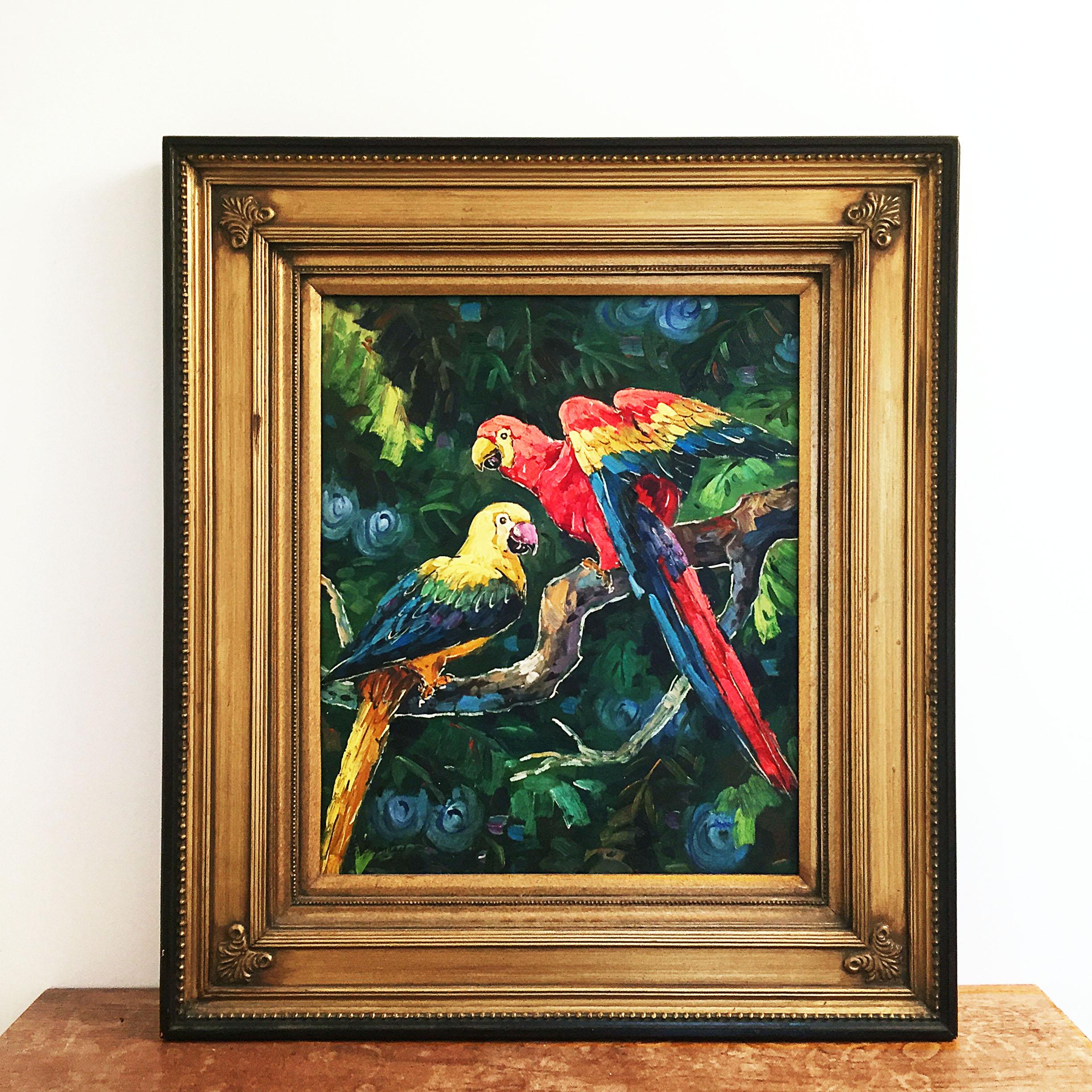 Une belle peinture exotique à l'huile sur toile représentant deux perroquets dans une jungle. Des couleurs vibrantes brossées au pinceau et encadrées dans un lourd cadre en bois doré et en plâtre. Fabriqué dans les années 1990 et signé de façon