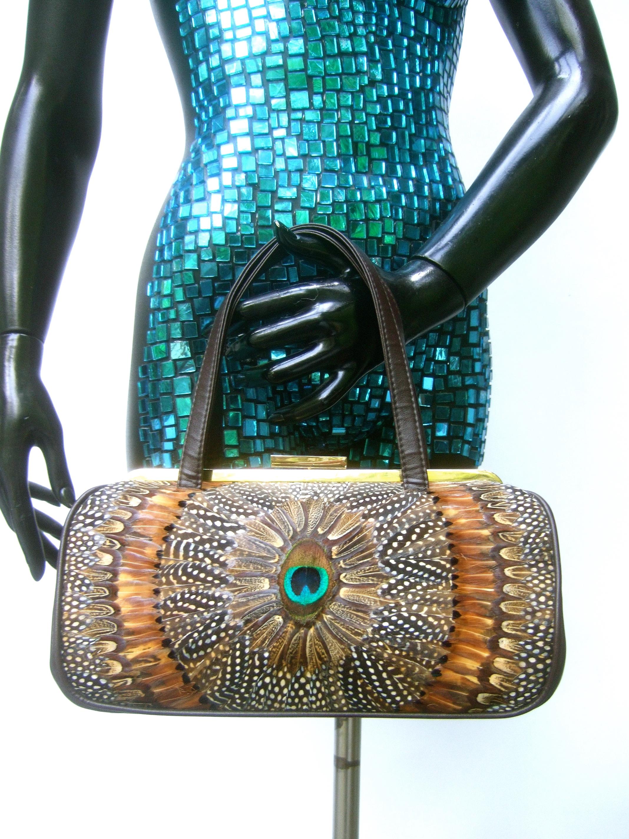 Bolso estructurado de plumas de ave exótica de plumaje de pavo real c 1970s
El bolso único está diseñado con plumas de ave en ambos lados exteriores
con una pluma de pavo real colocada en el centro

Diseñado con un elegante marco de cierre de metal