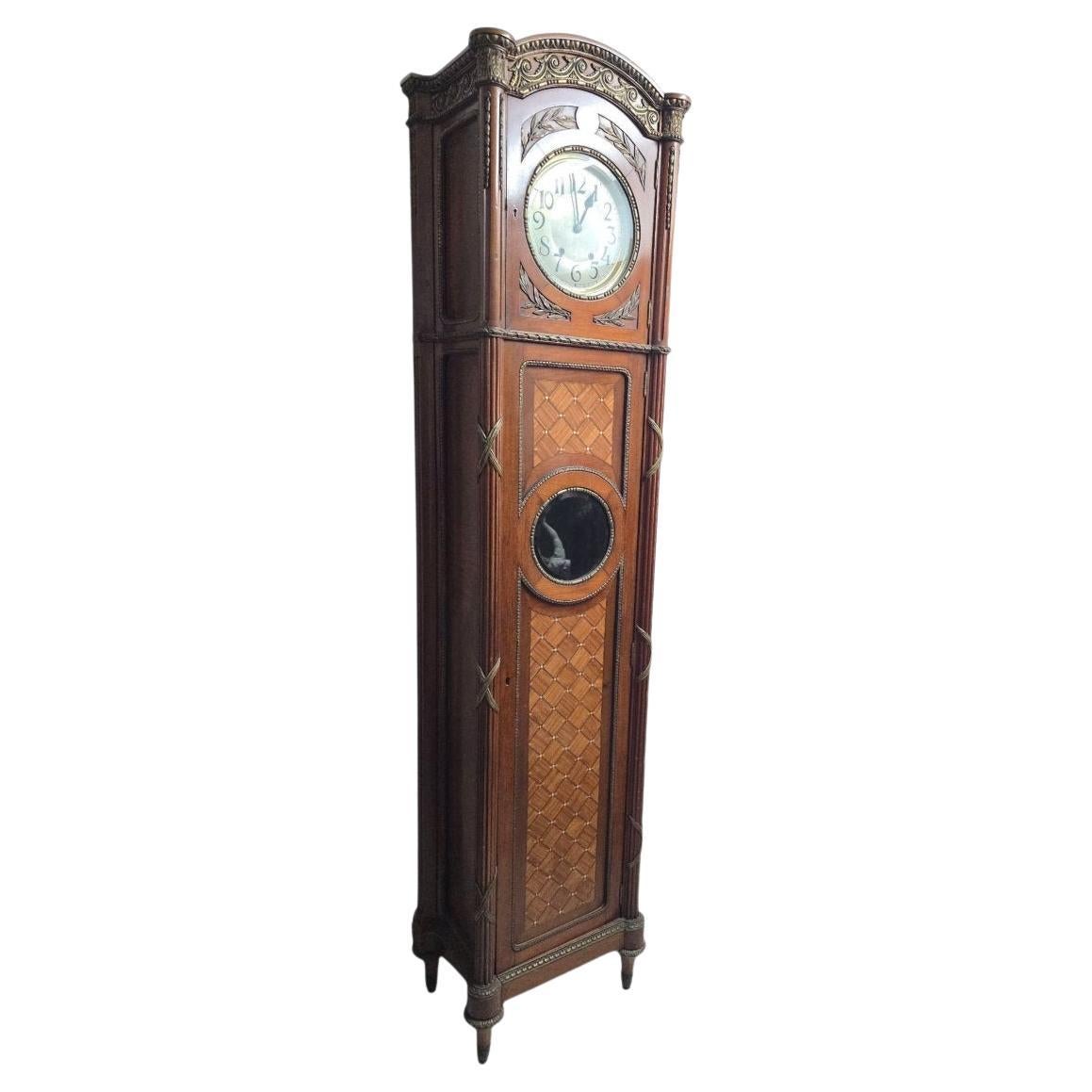 Superb tall longcase clock, crafted from finely crafted exotic woods and decorated with mother-of-pearl inlays forming an elegant geometric pattern. The brass details and marquetry highlight the rich craftsmanship of this unique piece.

It is
