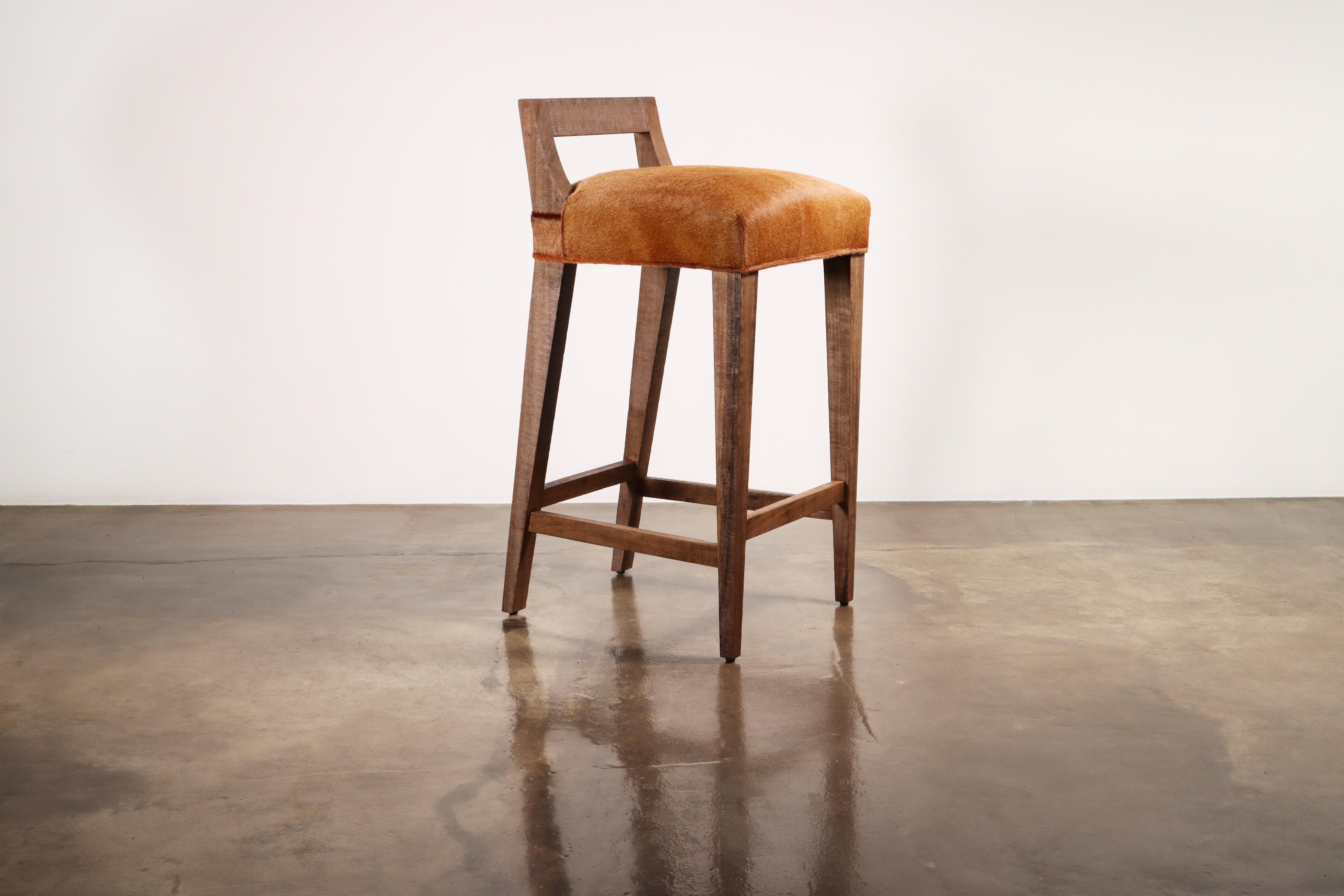 The Ecco Stool features a low, open, angular single slat back that can be easily handled for moving them around. Available in counter or bar height and your choice of upholstery. Shown in hair hide leather with an aged wood finish.  

About