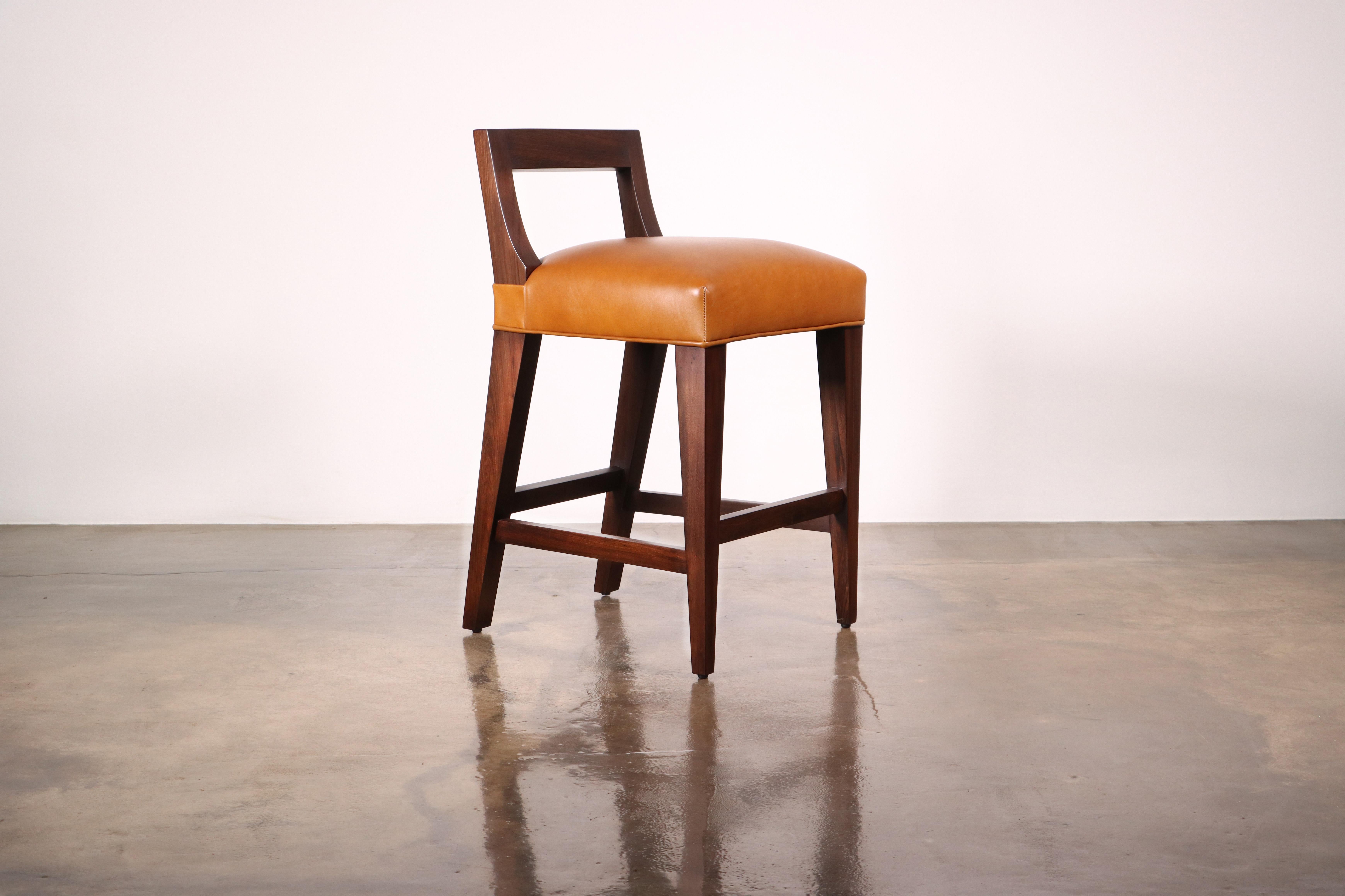 The Ecco Stool features a low, open, angular single-slat backrest that doubles as a handle for easy movement. Available in counter or bar height and customizable in the upholstery of your choice. Shown in a dark walnut finish.

Other materials