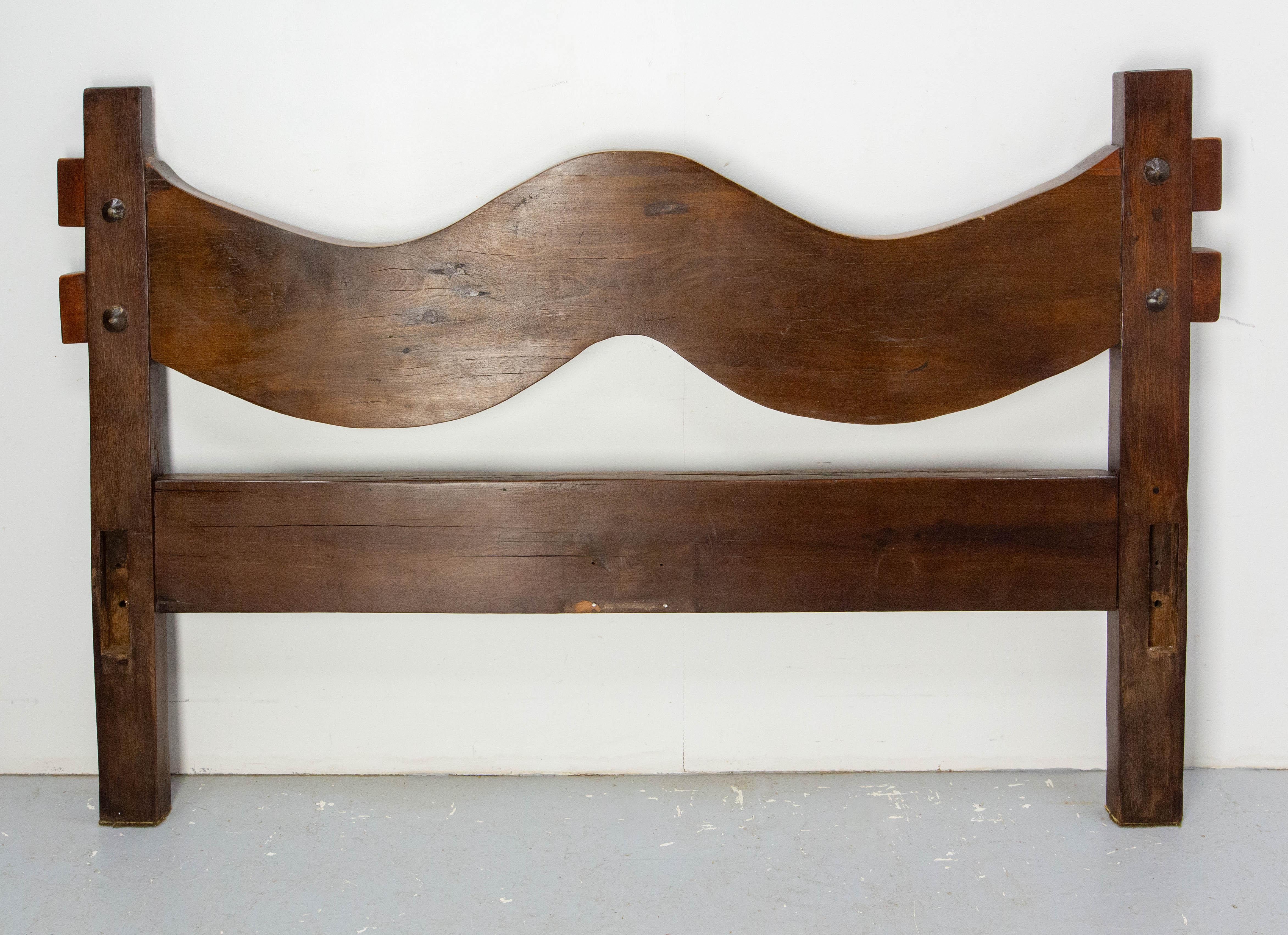 Testiera francese in legno esotico massiccio realizzata nel 1960 circa in Brasile.
Su questa testiera rustica, entrambe le facce hanno un interesse. 
Una ha grandi borchie e dall'altra parte il legno ha mantenuto un aspetto brutalista: è stato