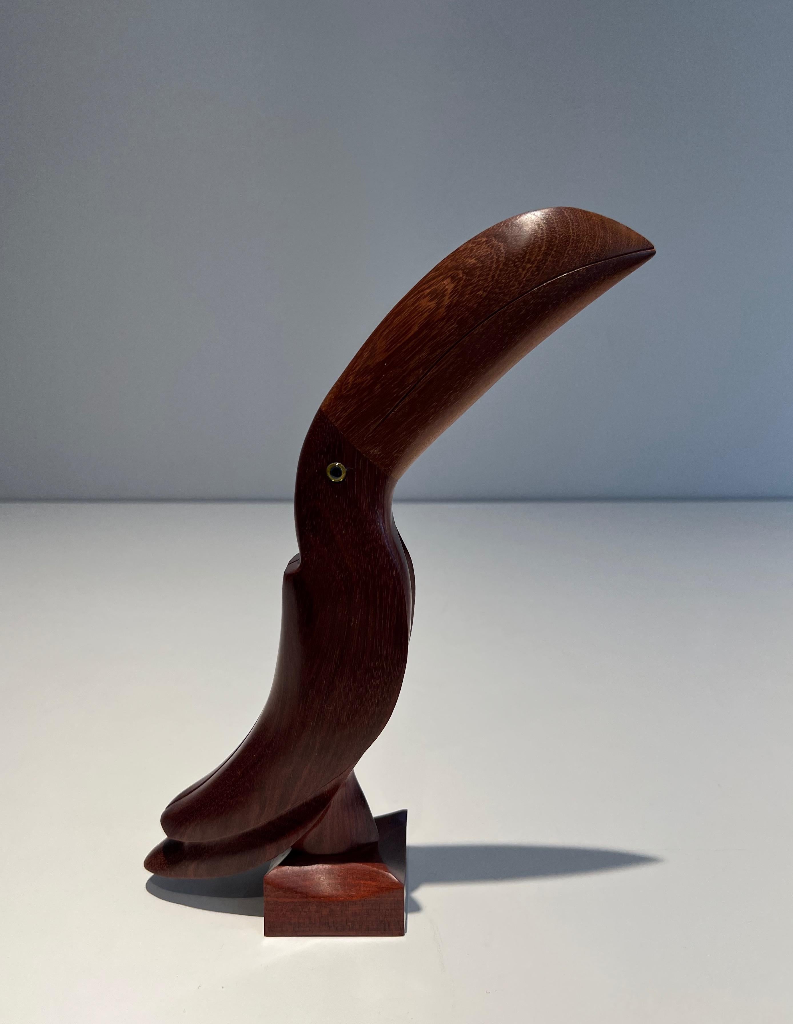 This sculpture representing a toucan is made of exotic wood with glass eyes. This is probably a French work. Circa 1970