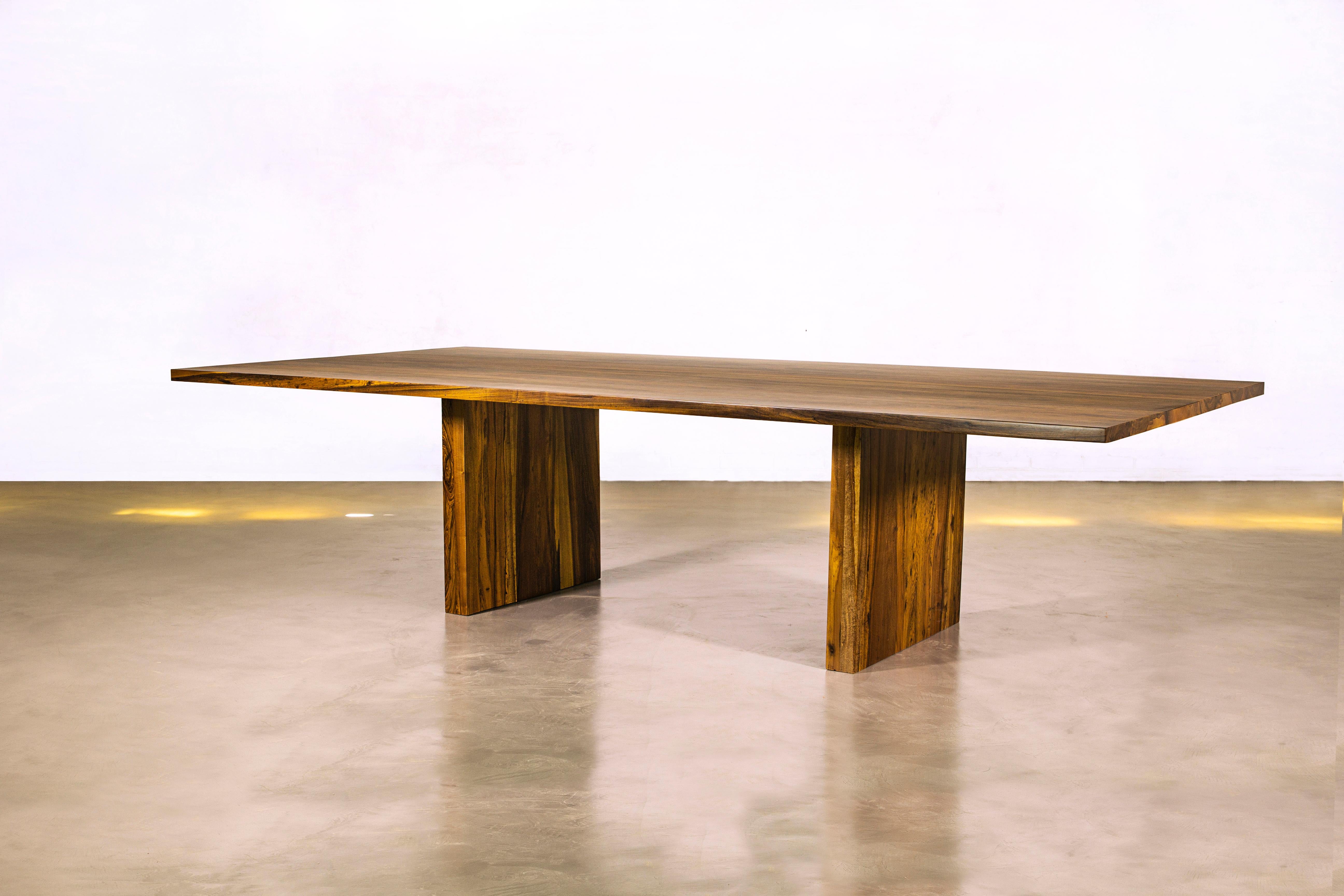 The Andre Table is shown here in natural Argentine Rosewood, with two solid wood pedestals. This piece comes in any of our standard wood species and finishes, and in any size. Made to order, but some sizes may be in stock and ready for immediate