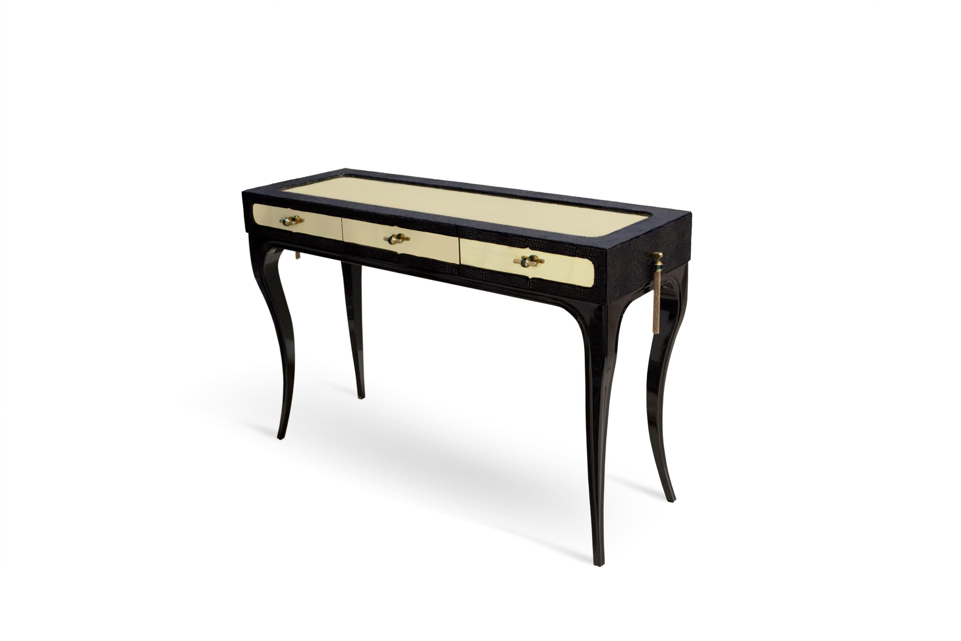 Exuding feelings of fantasy, this highly coveted dressing table is bold, daring and seductive. Her wooden frame is cloaked in an exotic fabric with a complementing metal top, juxtaposed with the mesmerizing movements of shimmering glass