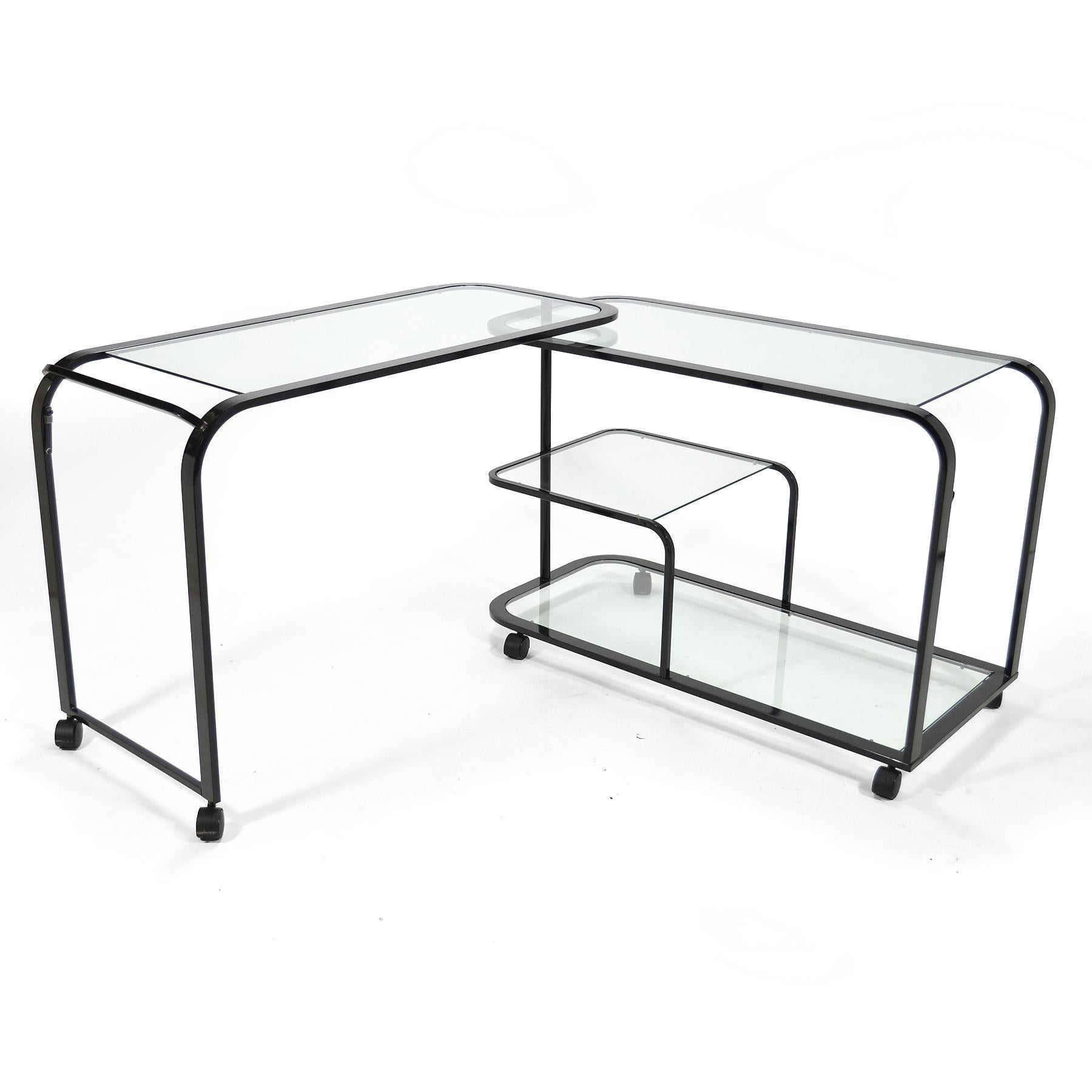 This great bar cart or serving cart by Design Institute of America can unlatch, swing open, and double in size to serve a large party. More commonly seen in brass or chrome, the black finish on the frame of this example lends a stronger graphic