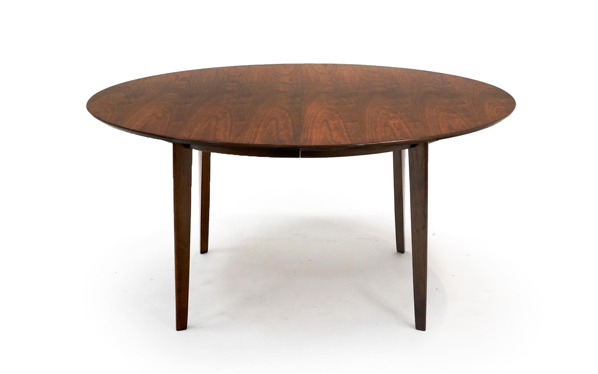 Walnut oval, almost round, dining table with two leaves designed by Edward Wormley for Dunbar. Heavy duty construction. Original finish with only very light signs of wear if any.  This table will see 10

Width without leaves is 60 inches. Each leaf
