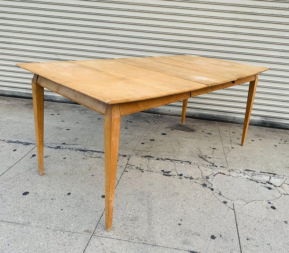 Vintage dining table with expandable mechanism designed and manufactured by Heywood Wakefield.

The table is solid wood and retains the original condition and needs to be refinished.

Measurements: 
68 inches wide with leaf x 54 inches wide