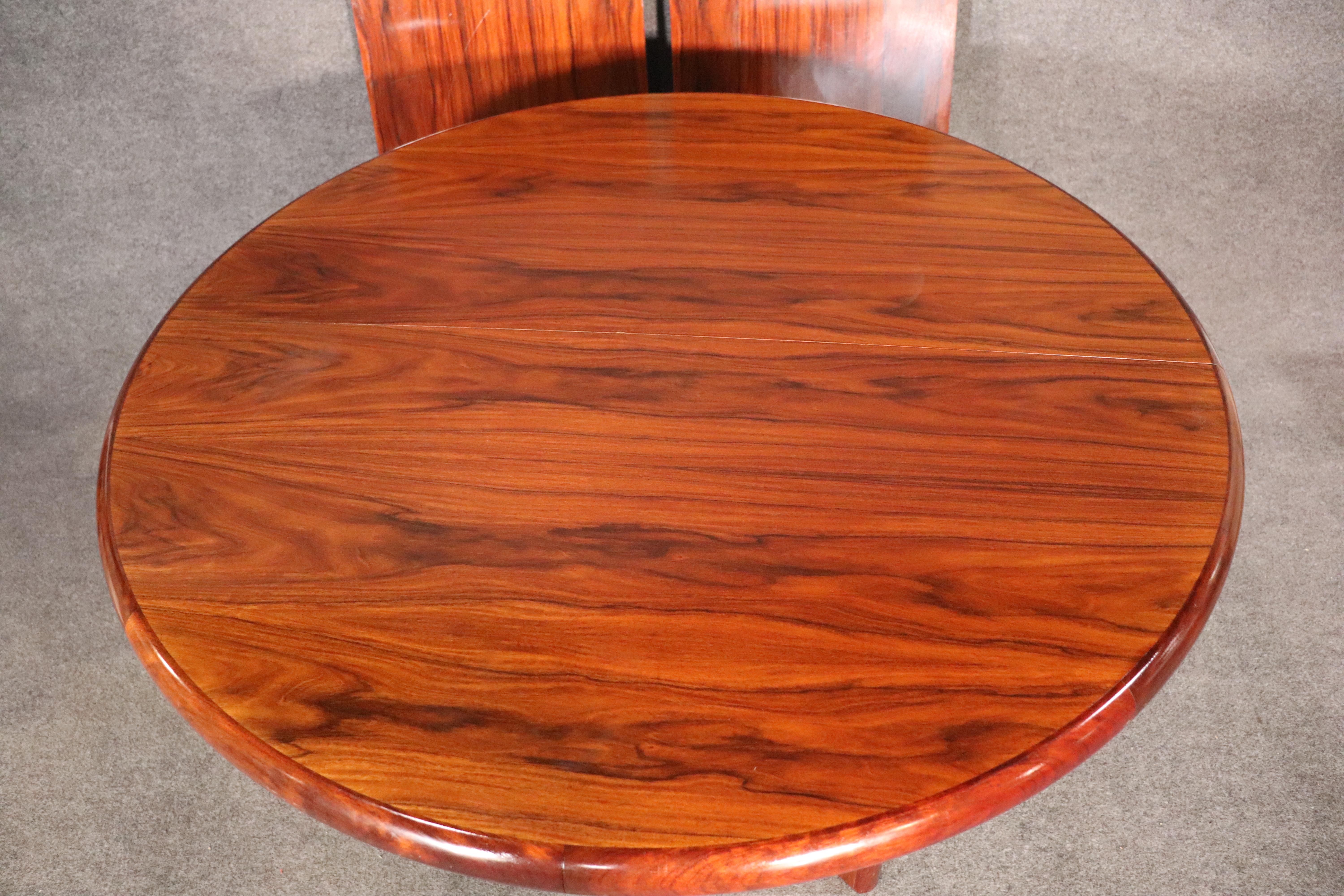 Table ronde danoise en bois de rose foncé sur deux bases angulaires. Livré avec deux feuilles de 19,75