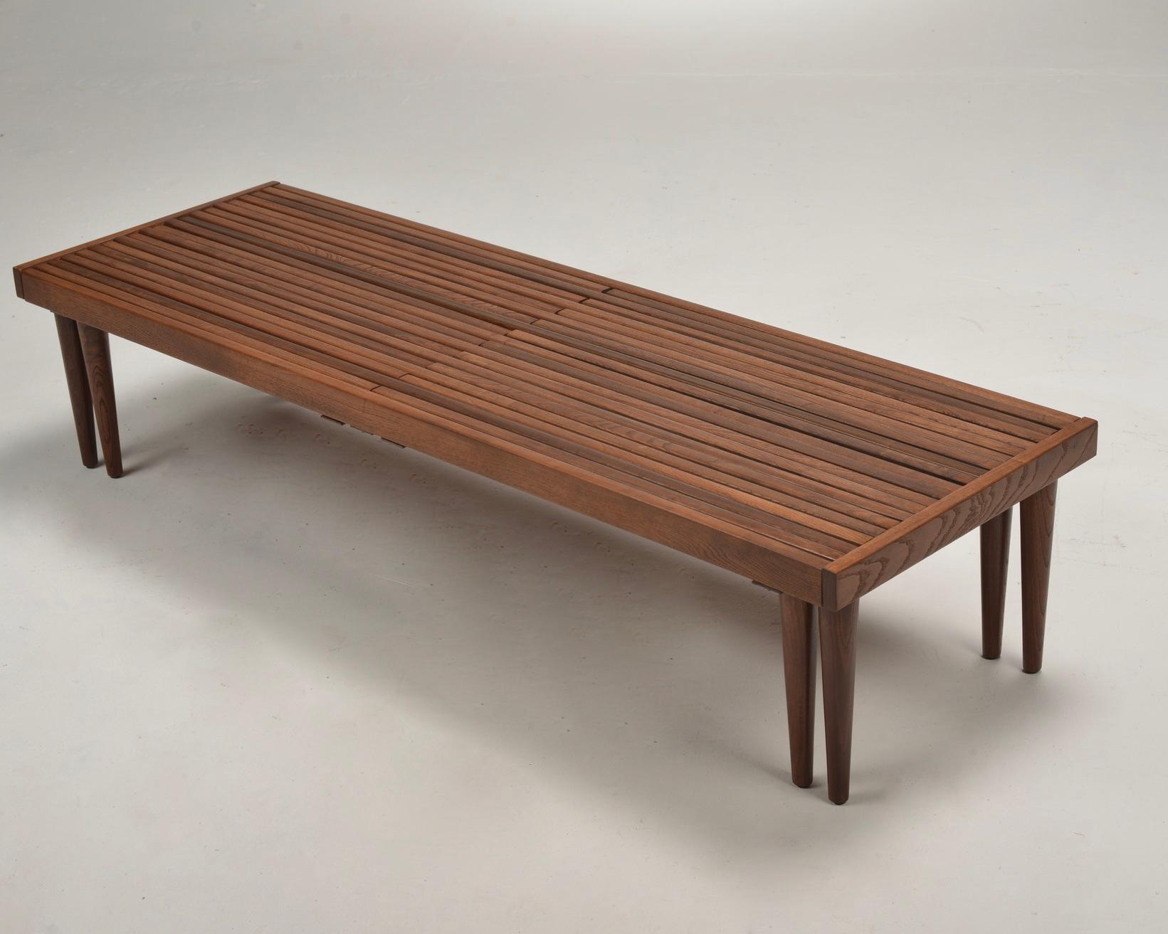 Midcentury Brown Saltman expandable slat bench designed by John Keal. This bench has two ends that pull-out extending to almost 94” long. A versatile solid walnut bench, coffee table, plant table, etc. The versatility of this piece speaks to the era