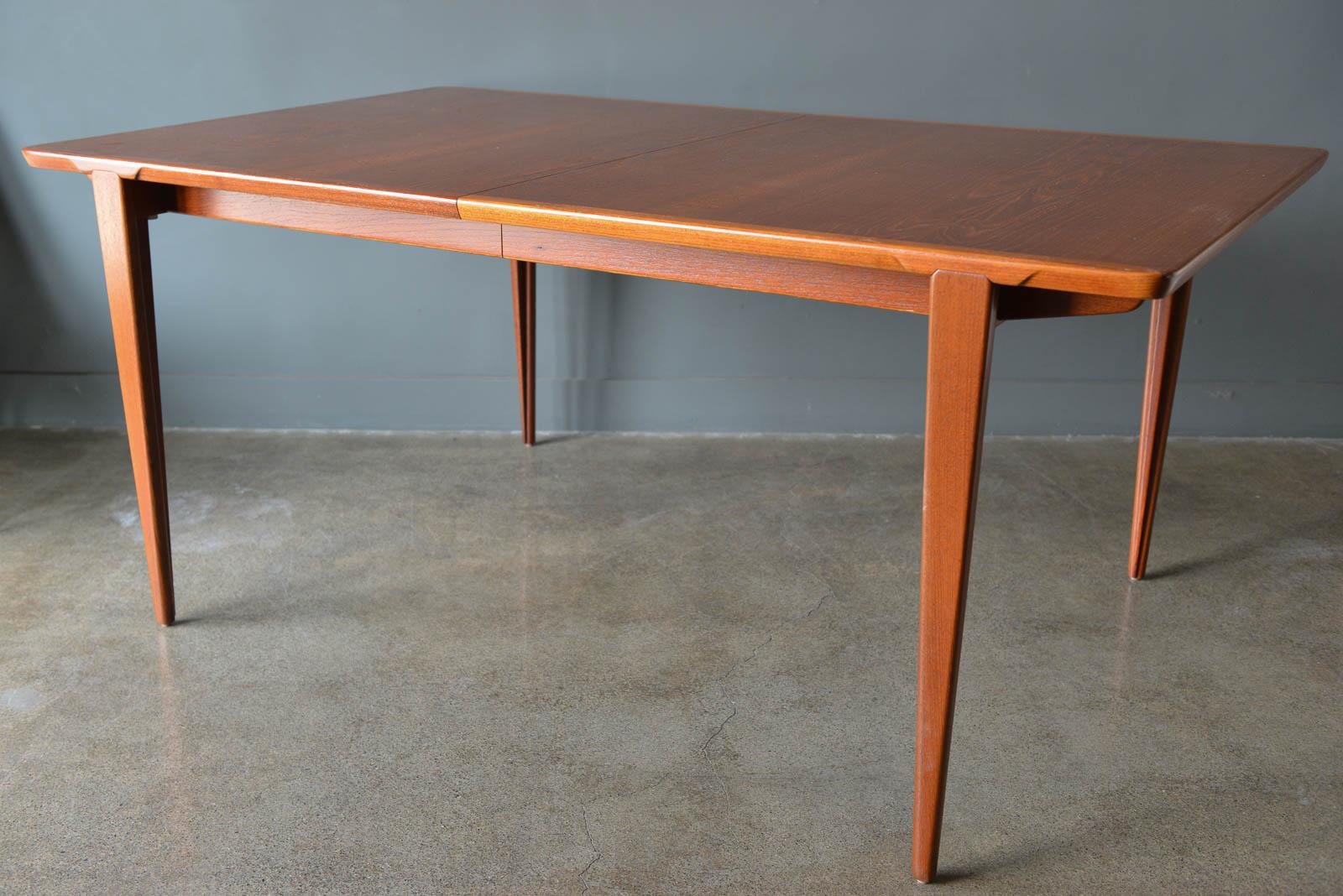 Expandable teak dining table by Henry Rosengren Hansen, ca. 1960. Gorgeous sculpted legs and interesting leg design with two hidden leaves that store inside the table. Very high quality craftsmanship on this table, not a mass produced piece and