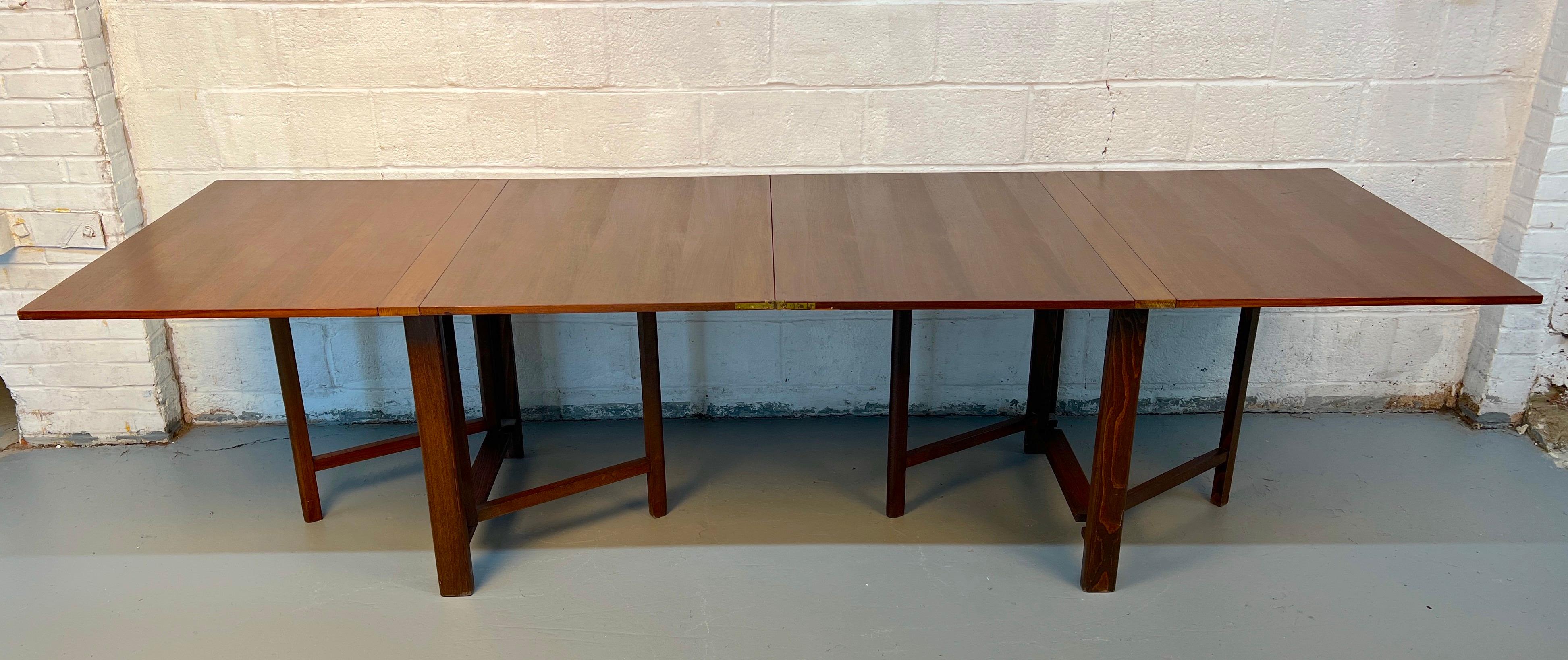 Table à abattant classique en noyer, avec un piètement traditionnel en forme de porte. Polyvalent et élégant, il offre une surface flexible tout en mettant en valeur la chaleur et le grain du noyer finement travaillé - parfait pour la salle à manger