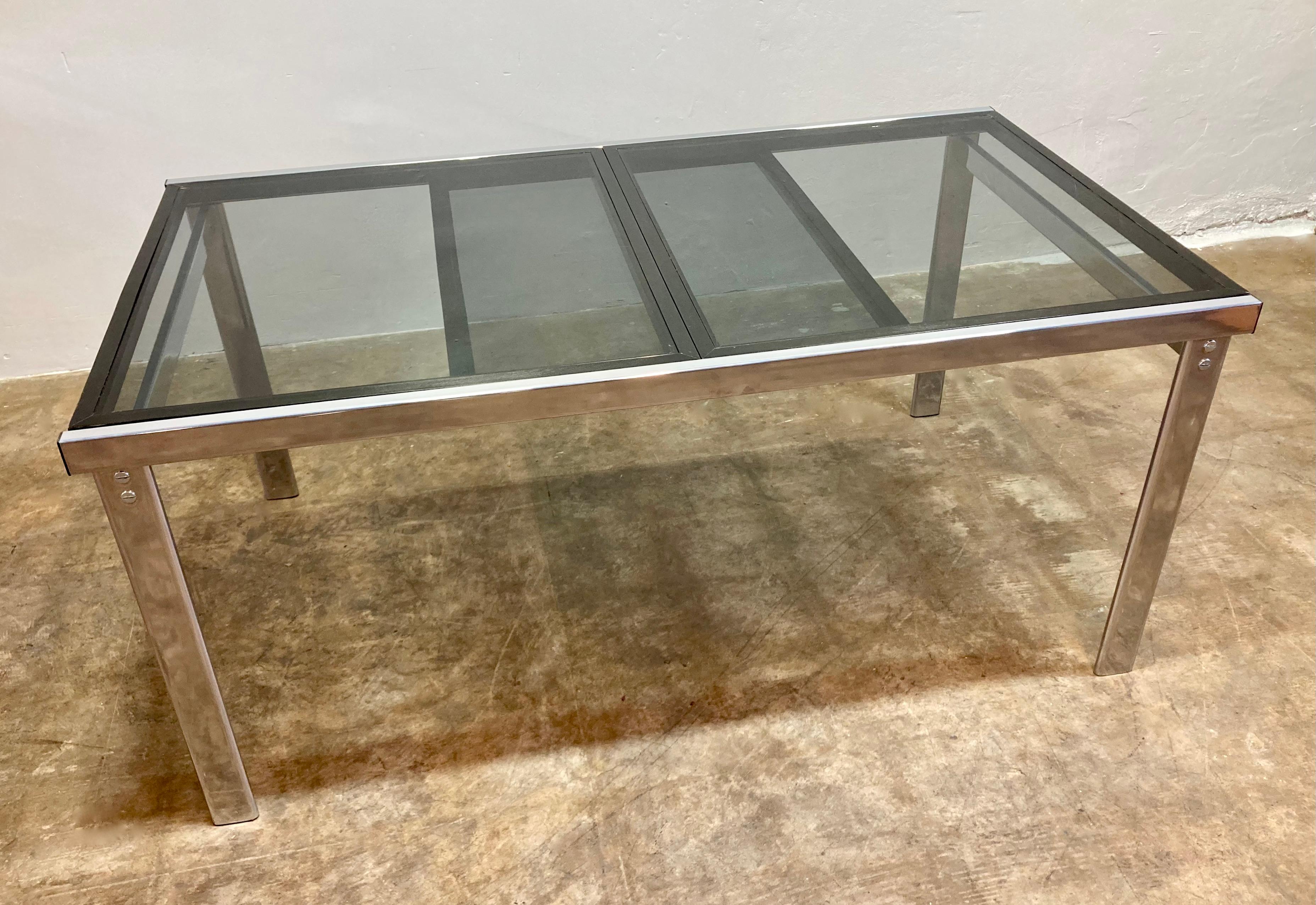 Table de salle à manger en expansion des années 1960. Entièrement restaurée en interne avec un nouveau revêtement en poudre de chrome sur le cadre et un plateau de table en verre fumé. Cadre coulissant en bois nouvellement peint en noir brillant.